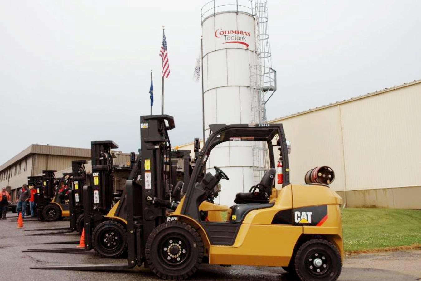 Caterpillar forklifts lined up outside a building HD Wallpaper
