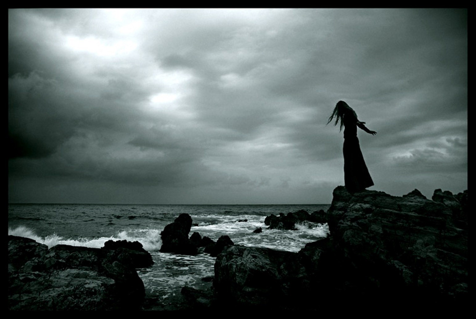 Gothic girl on rocky shore under stormy clouds HD Wallpaper
