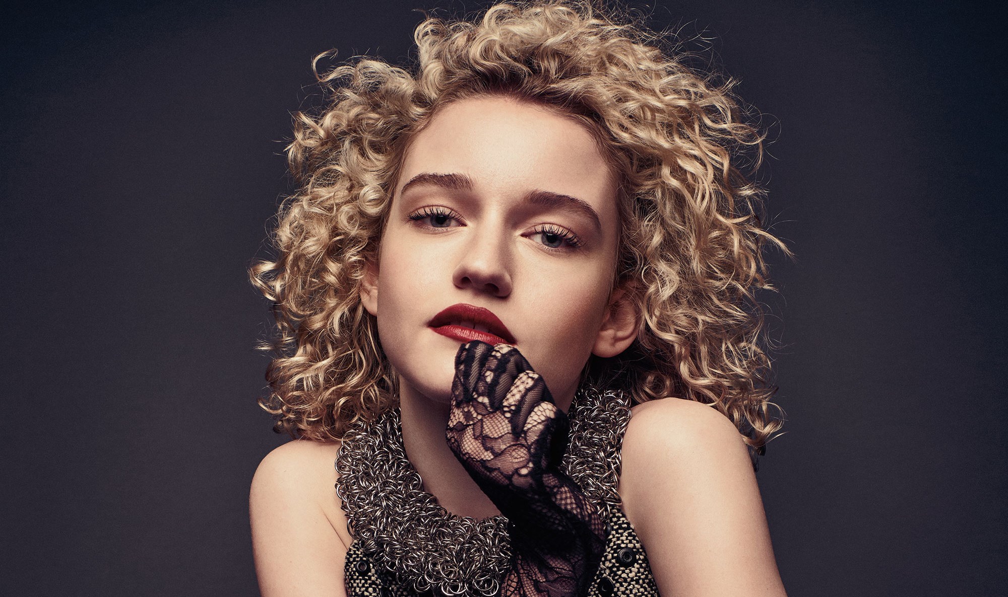Julia Garner with curly blonde hair and red lipstick HD Wallpaper
