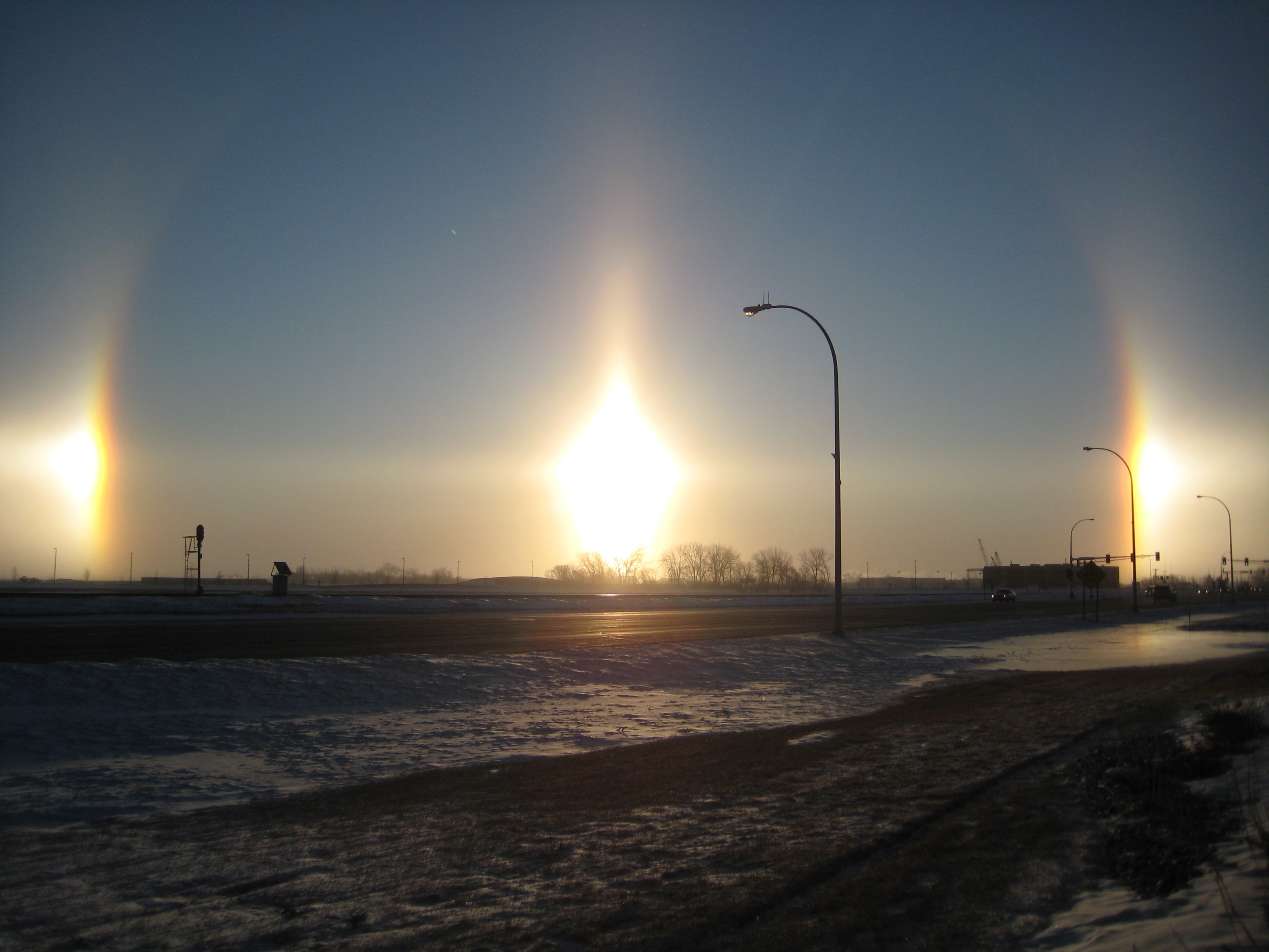 Sun Pillars and Parhelion Phenomenon Over Snowy Landscape HD Wallpaper