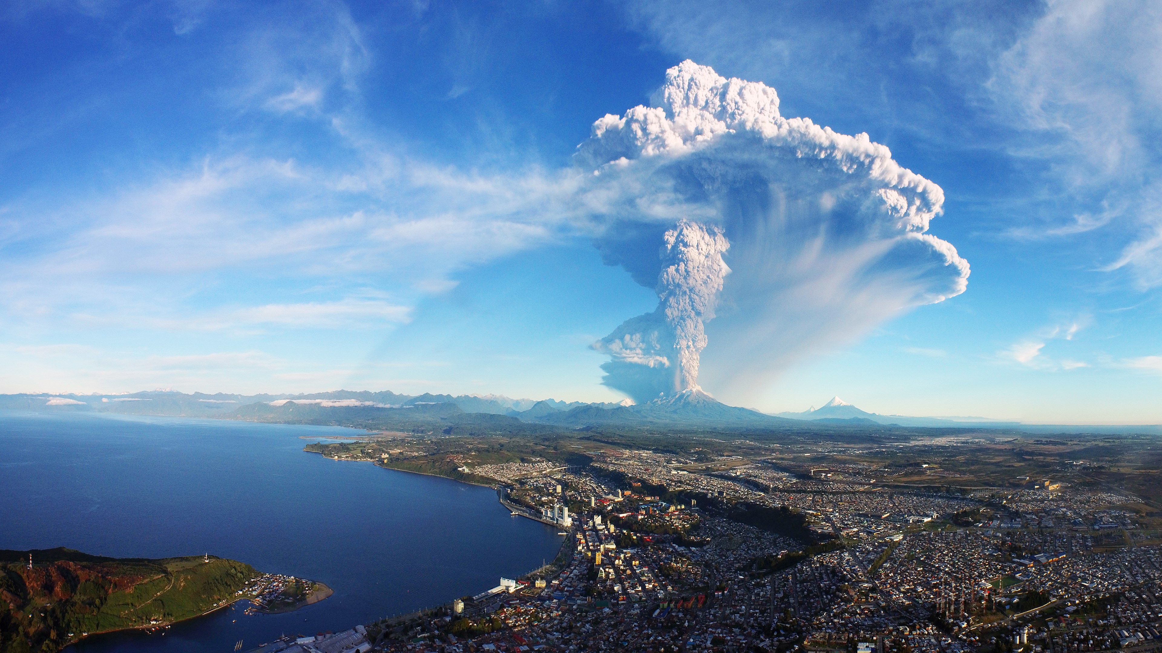 Volcanic eruption over a city and bay HD Wallpaper