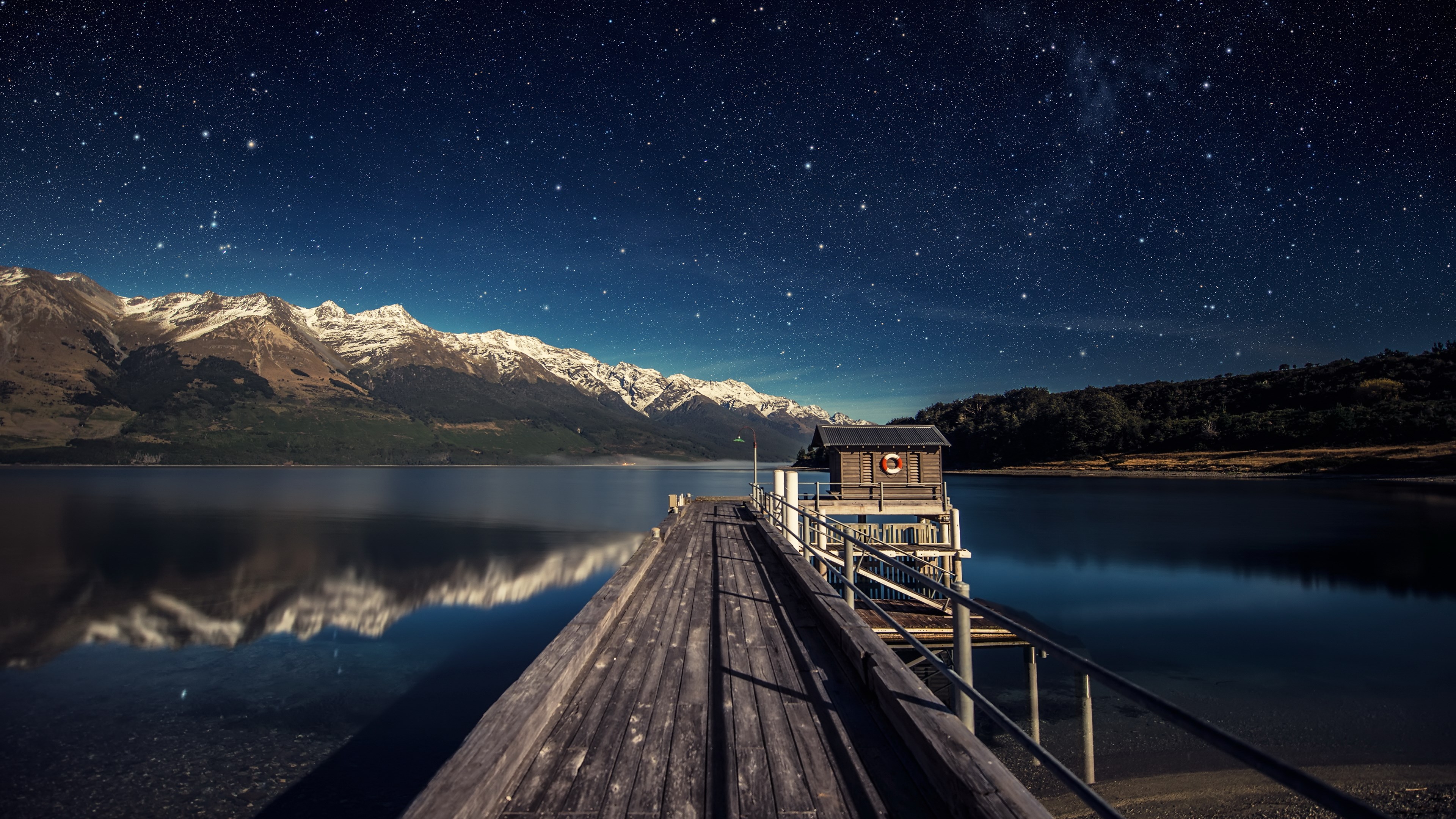 Wooden pier and boathouse under starry sky with mountains HD Wallpaper