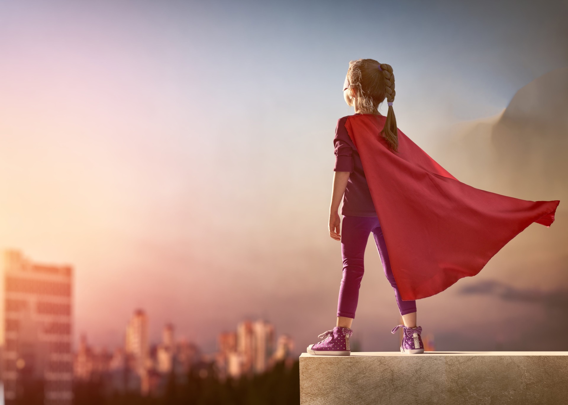 Girl in superhero cape looking over city HD Wallpaper