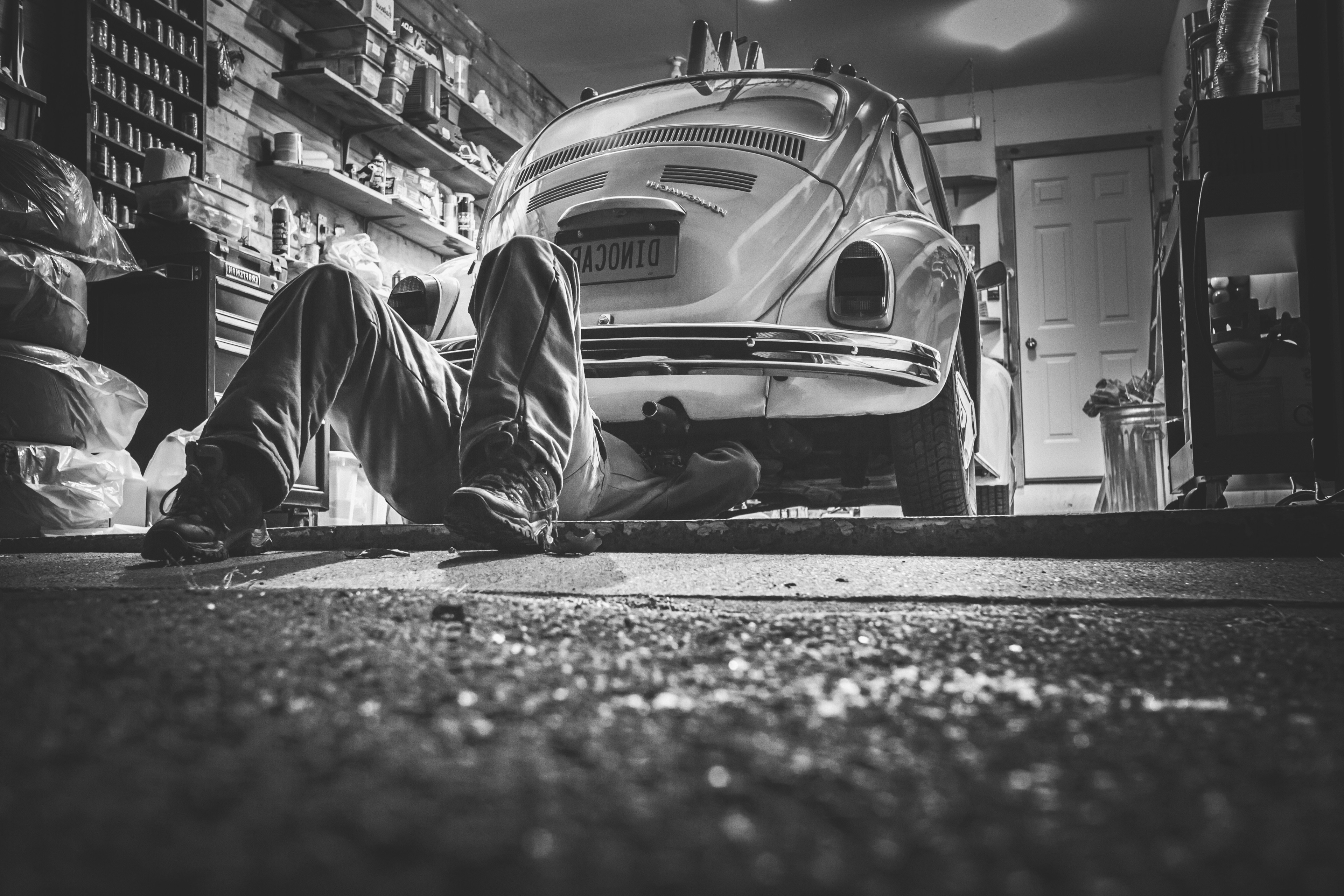Man working on a vintage Volkswagen Beetle HD Wallpaper