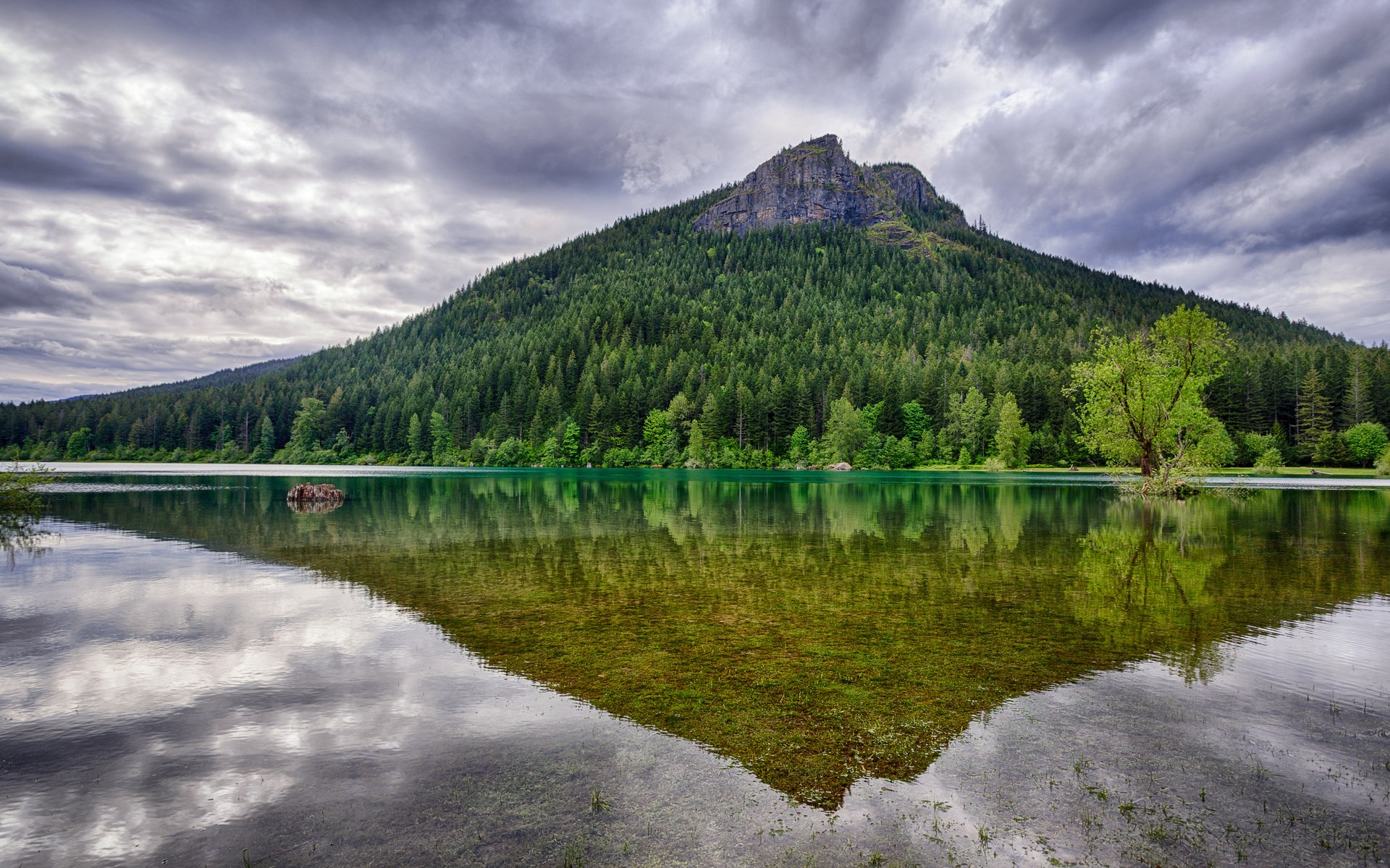 Mountain reflected in a lake with cloudy sky HD Wallpaper