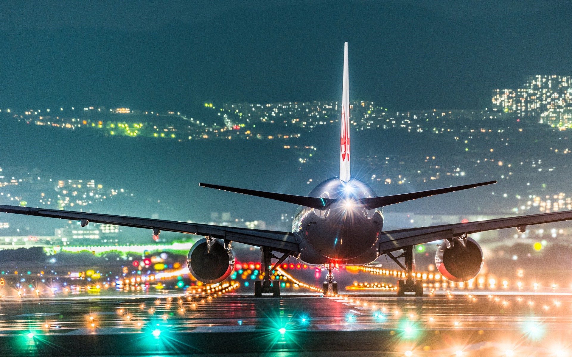Airplane on runway at night with city lights HD Wallpaper