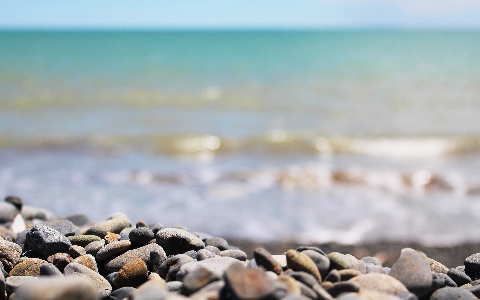 Beach with stones and the sea HD Wallpaper