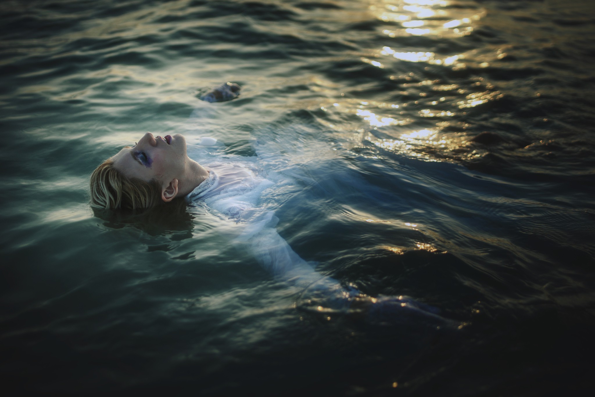 Woman floating in dark water HD Wallpaper