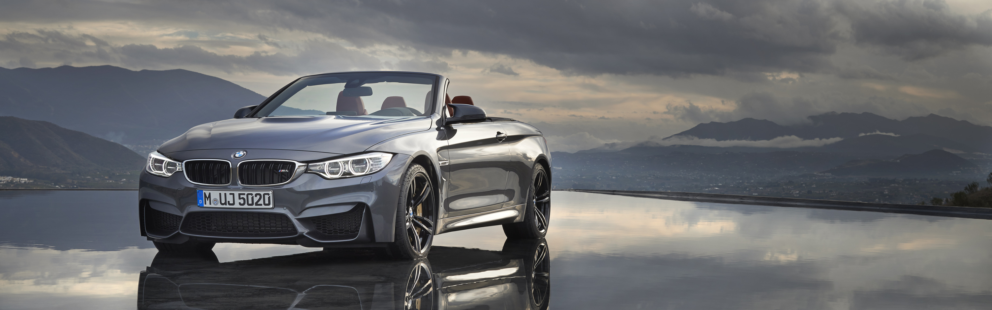 BMW M4 Convertible on reflective surface with mountains HD Wallpaper