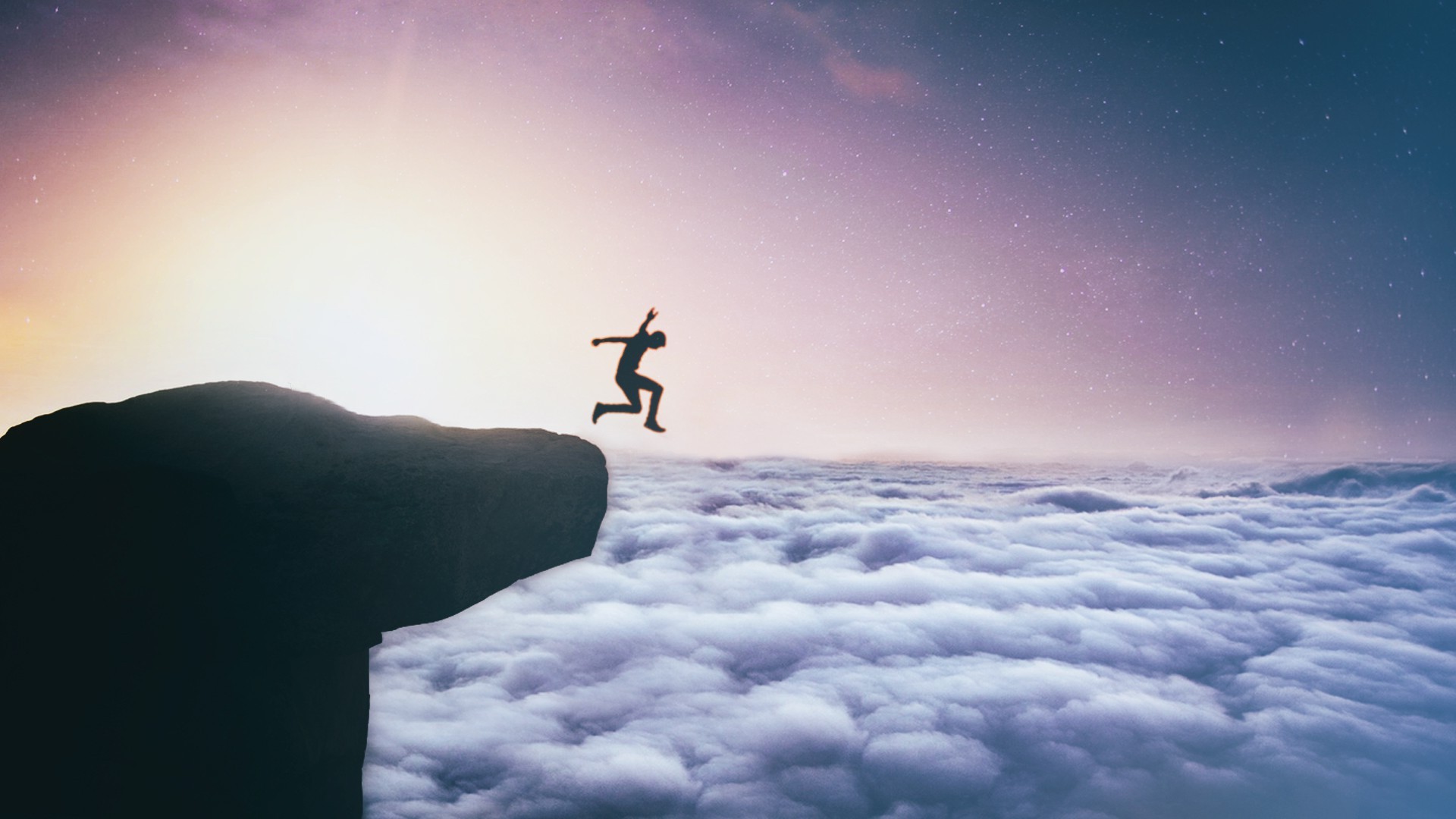 Silhouette of a person jumping off a cliff into clouds at night HD Wallpaper