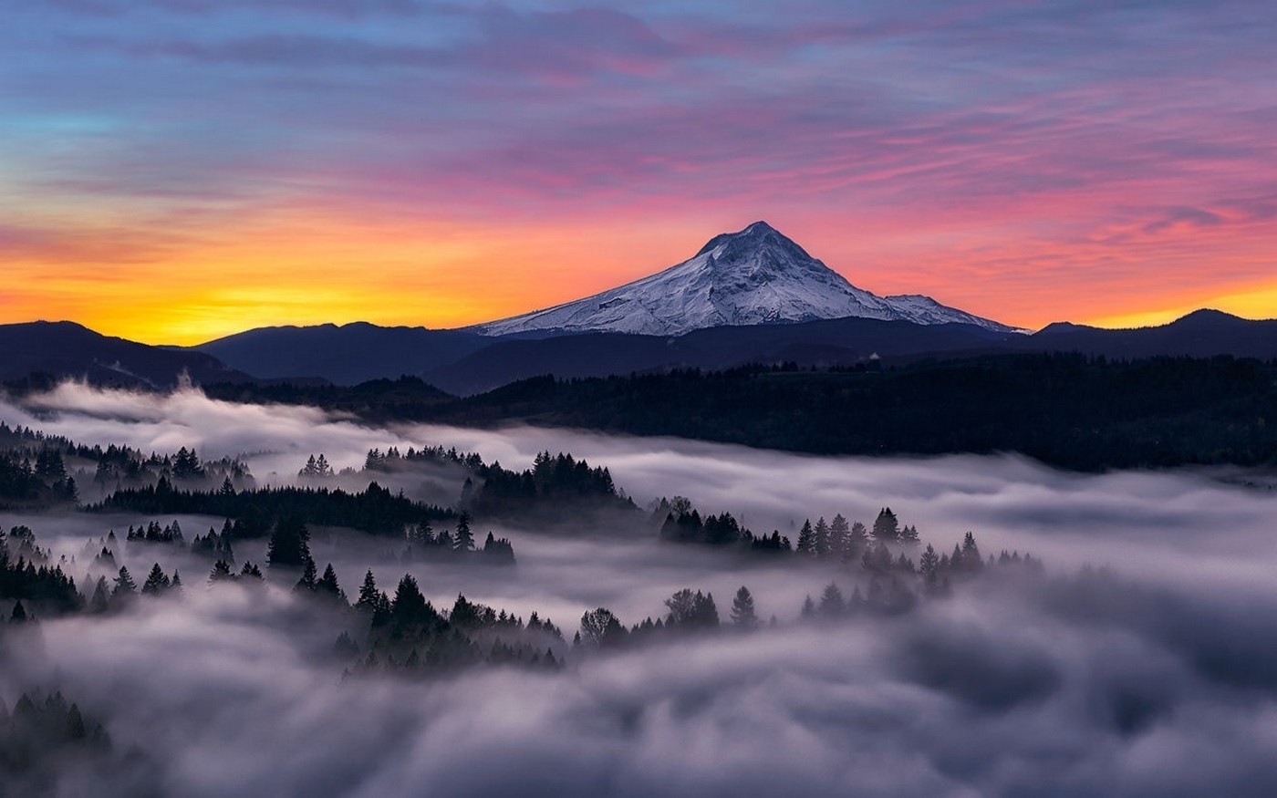 Snowy mountain peak at sunrise over misty forest HD Wallpaper