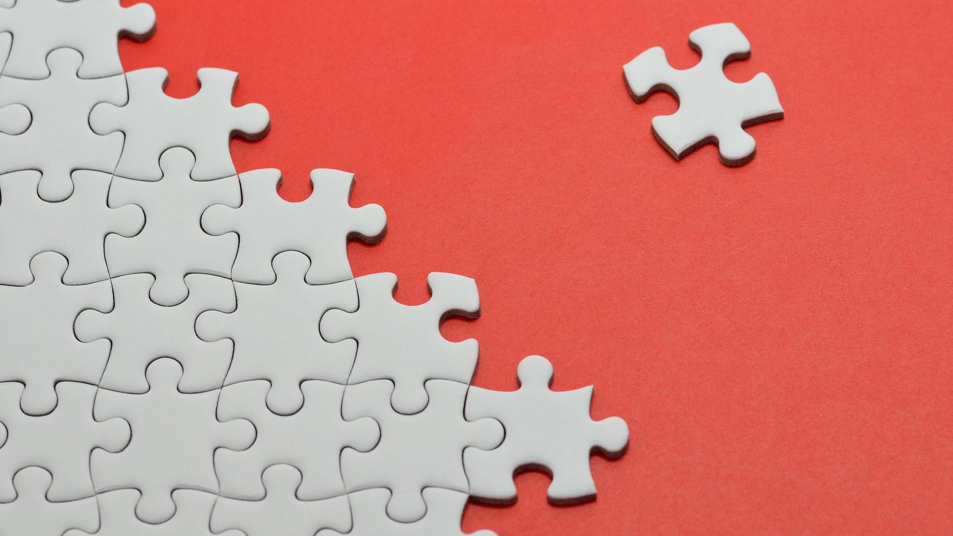 White puzzle pieces on a red board HD Wallpaper