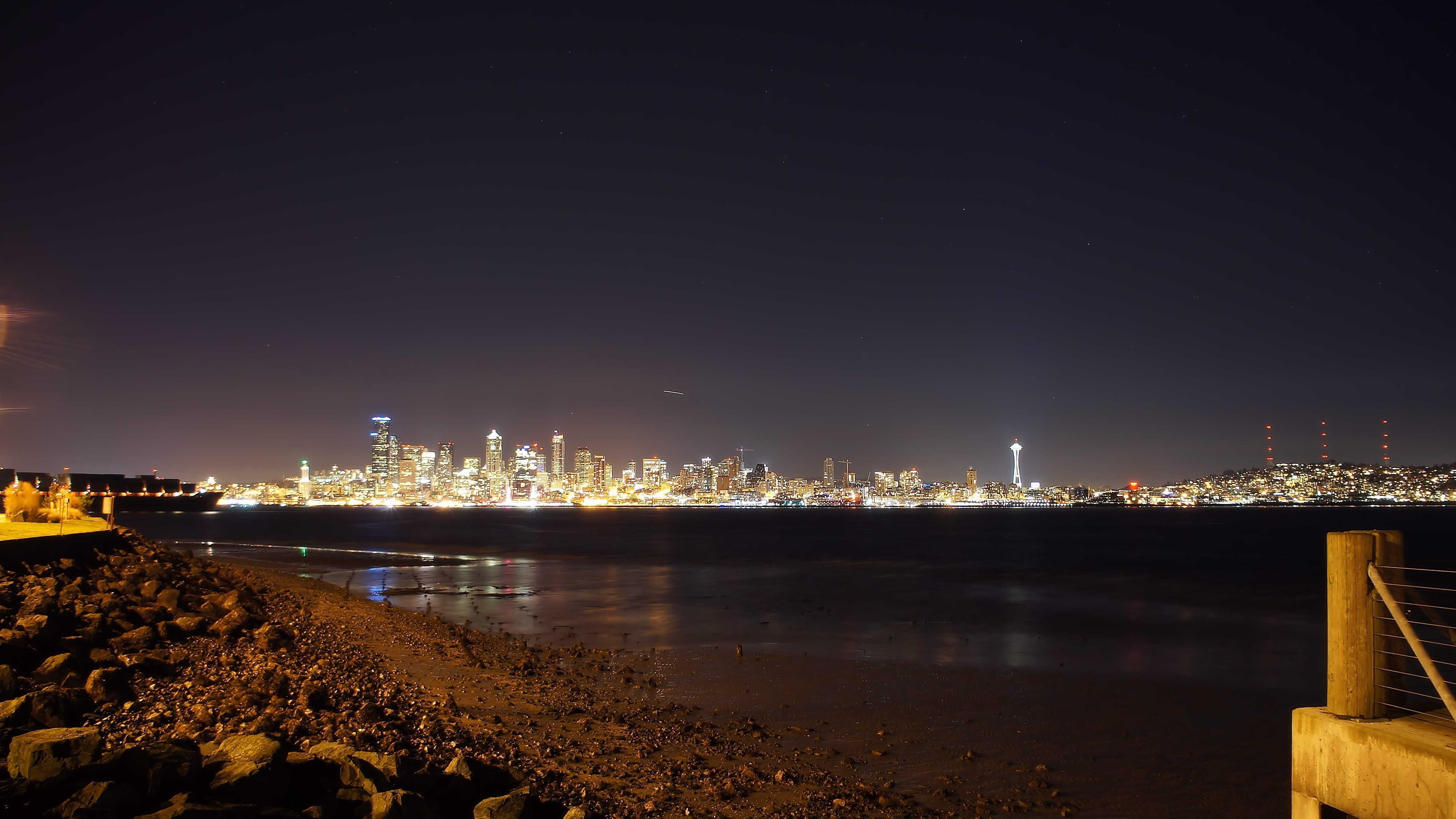 Seattle skyline at night from a rocky beach HD Wallpaper