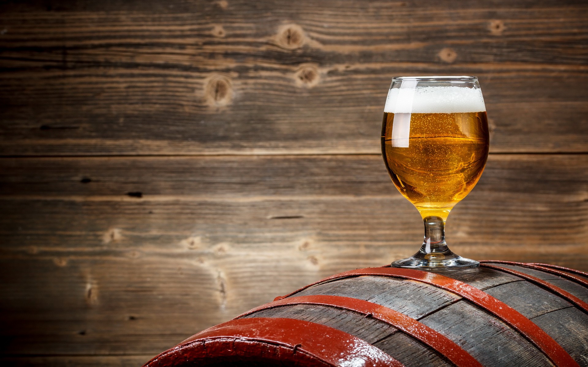 Glass of beer on a wooden barrel HD Wallpaper