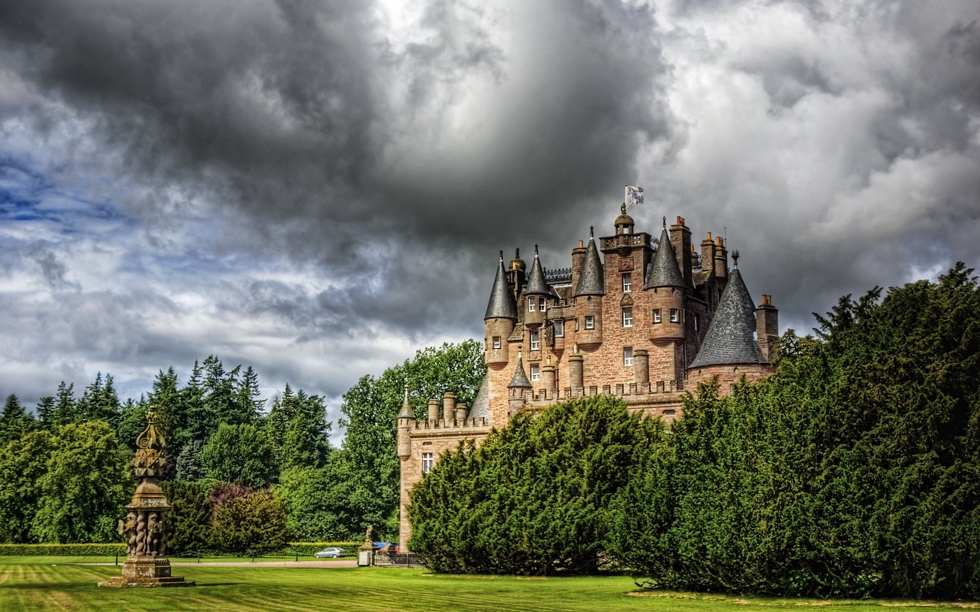 Castle surrounded by trees under a cloudy sky HD Wallpaper