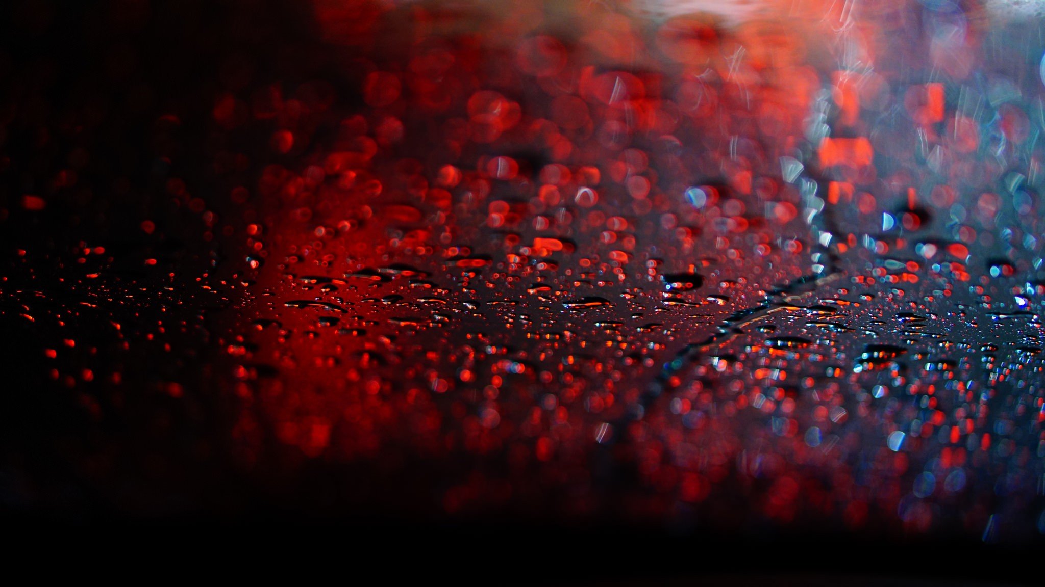 Raindrops on a dark surface with red bokeh HD Wallpaper