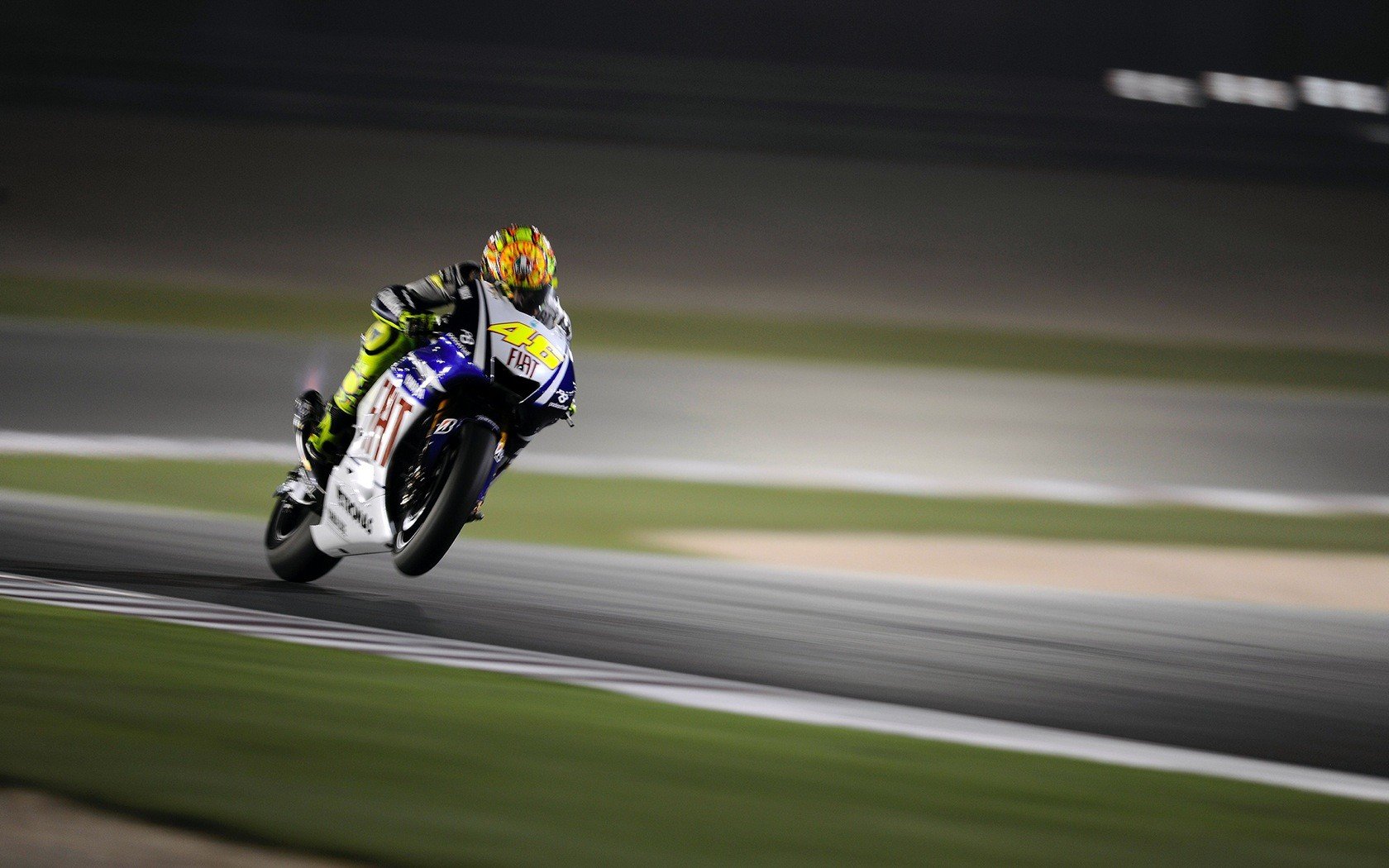 Valentino Rossi racing a motorcycle on a track HD Wallpaper