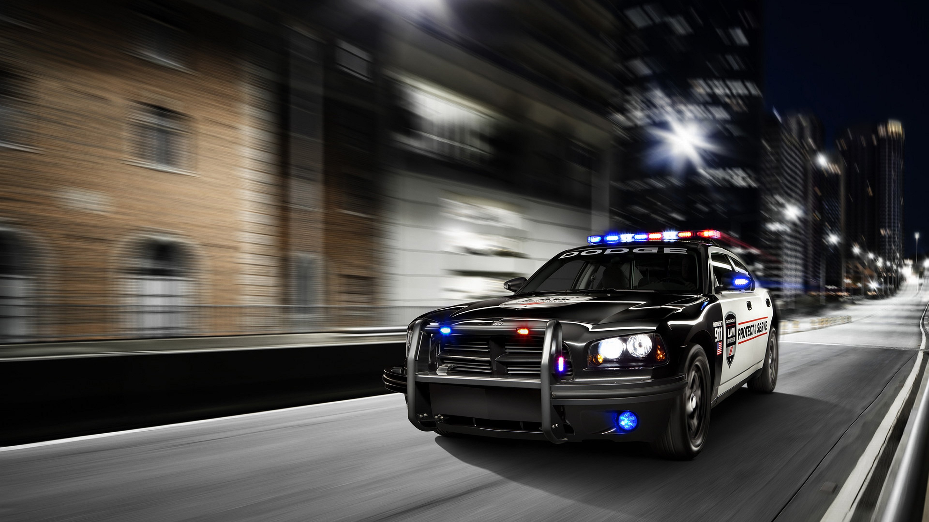 Dodge police car driving on a city street at night HD Wallpaper