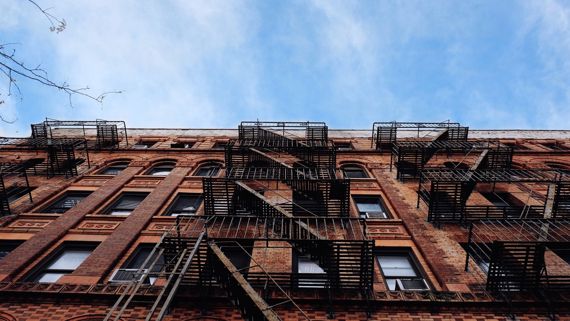Old brick building with fire escapes in New York City HD Wallpaper