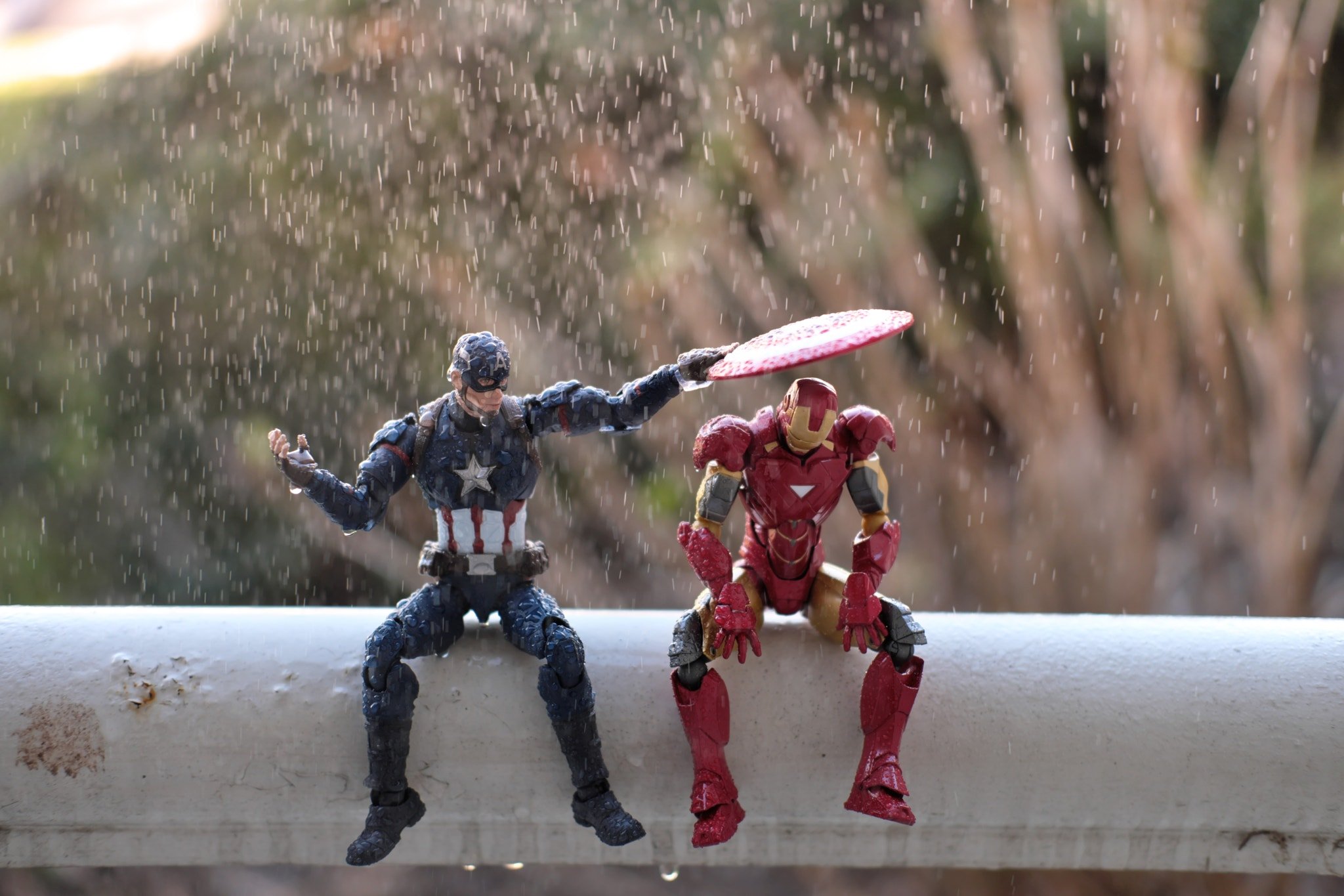 Captain America and Iron Man toys in the rain HD Wallpaper