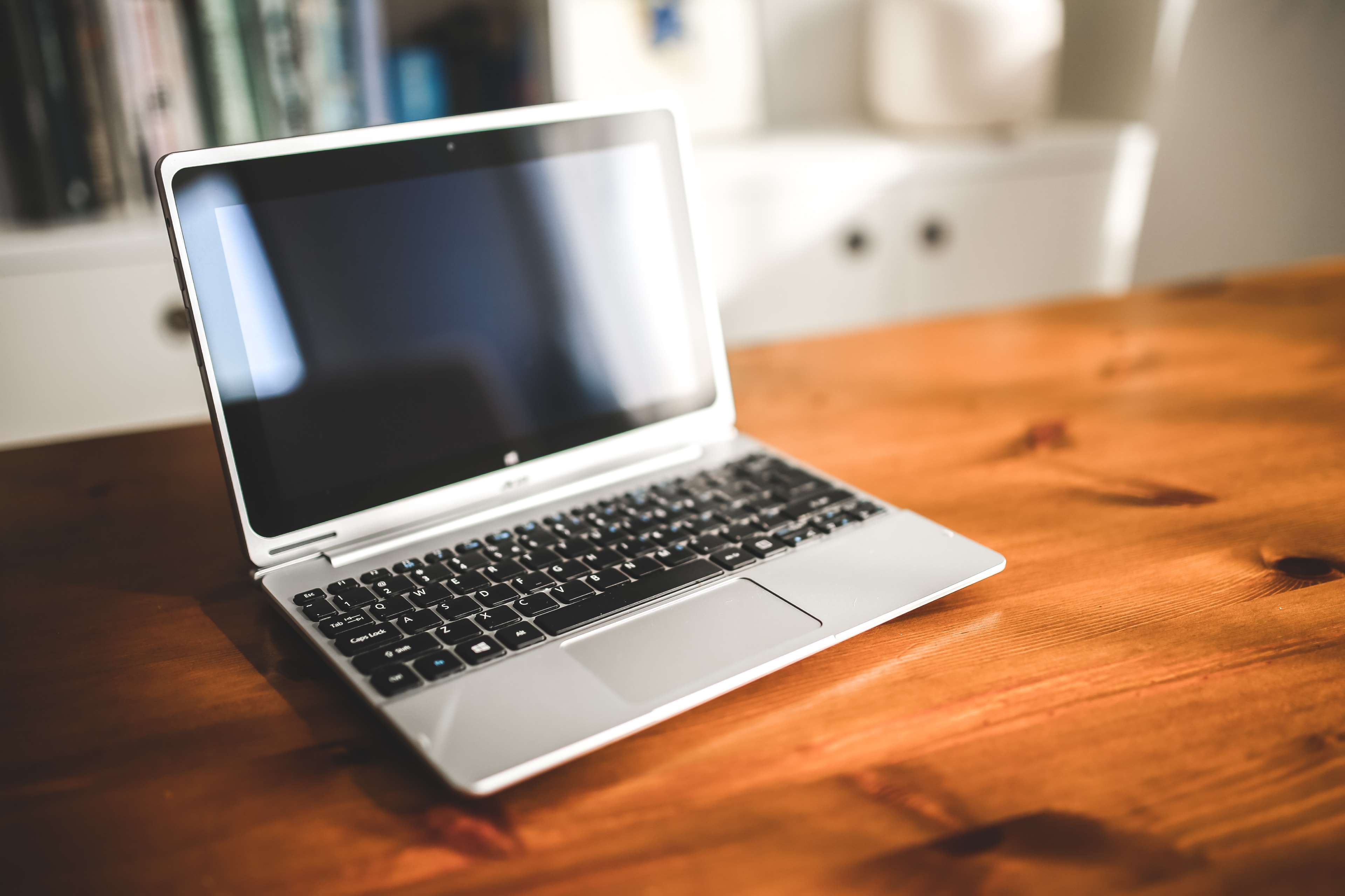 Laptop on a wooden desk with bokeh background HD Wallpaper