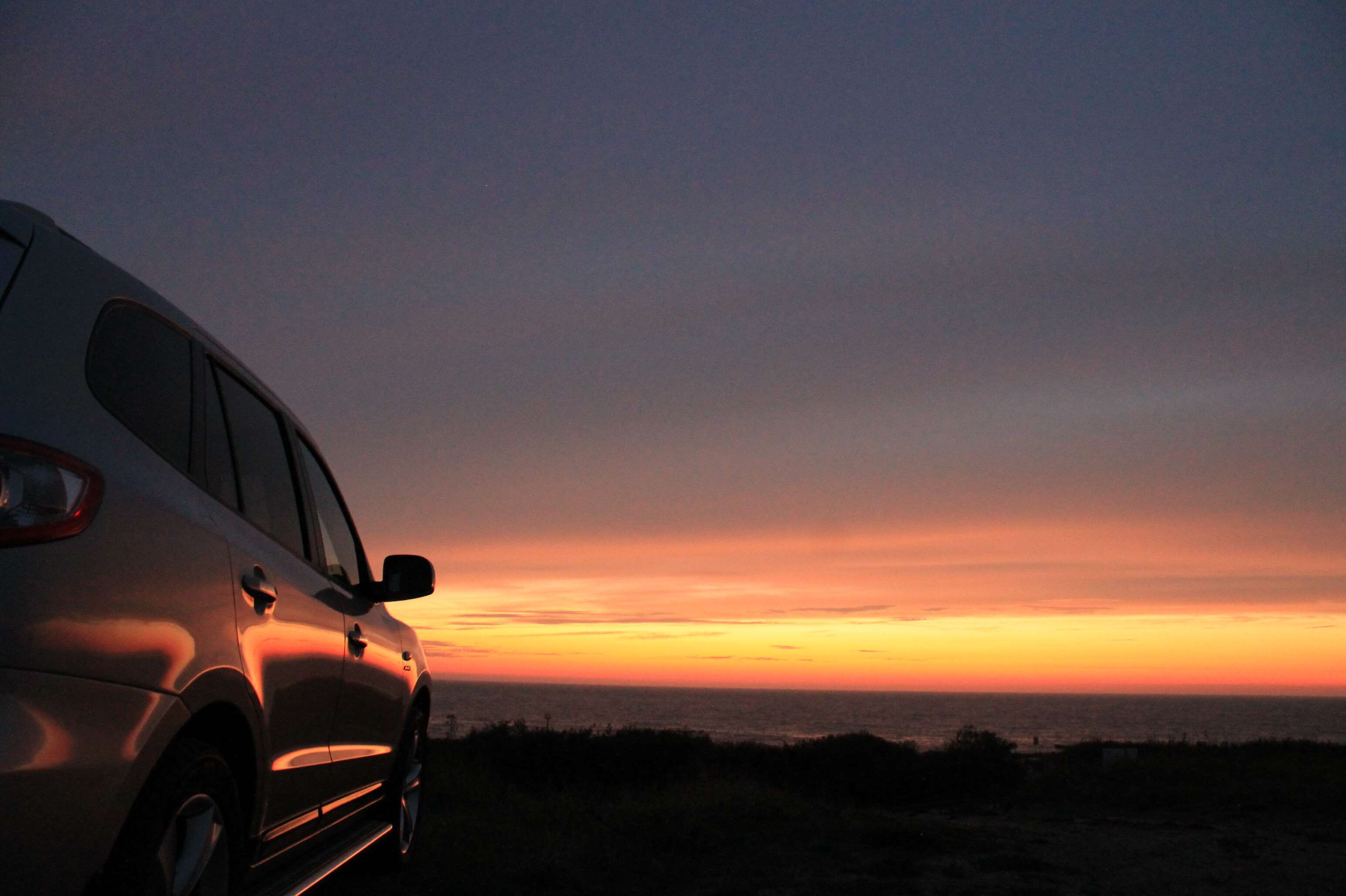 Hyundai car parked by the ocean at sunset HD Wallpaper