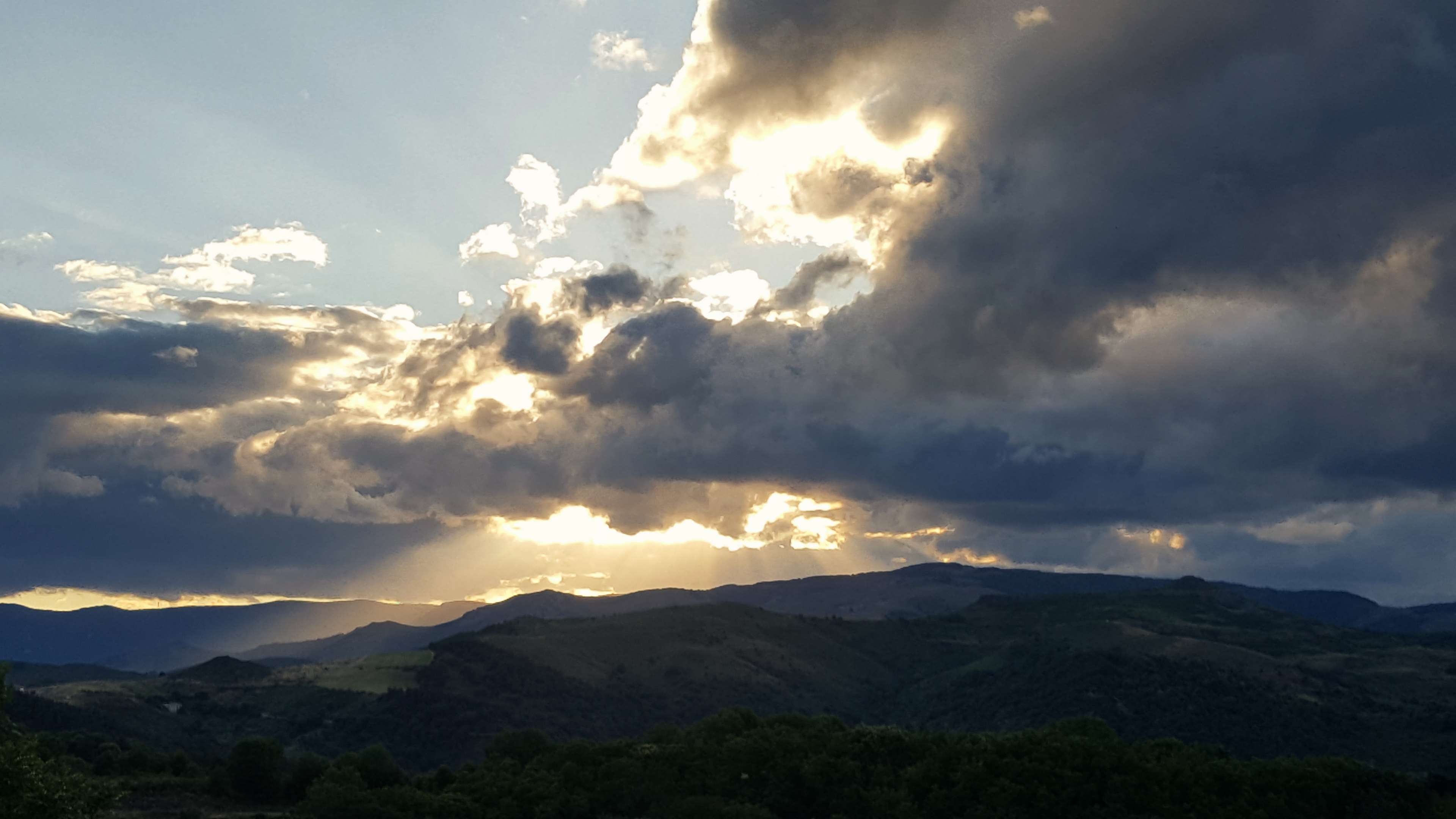 Sunbeams through stormy clouds over Ardeche landscape 4K HD Wallpaper