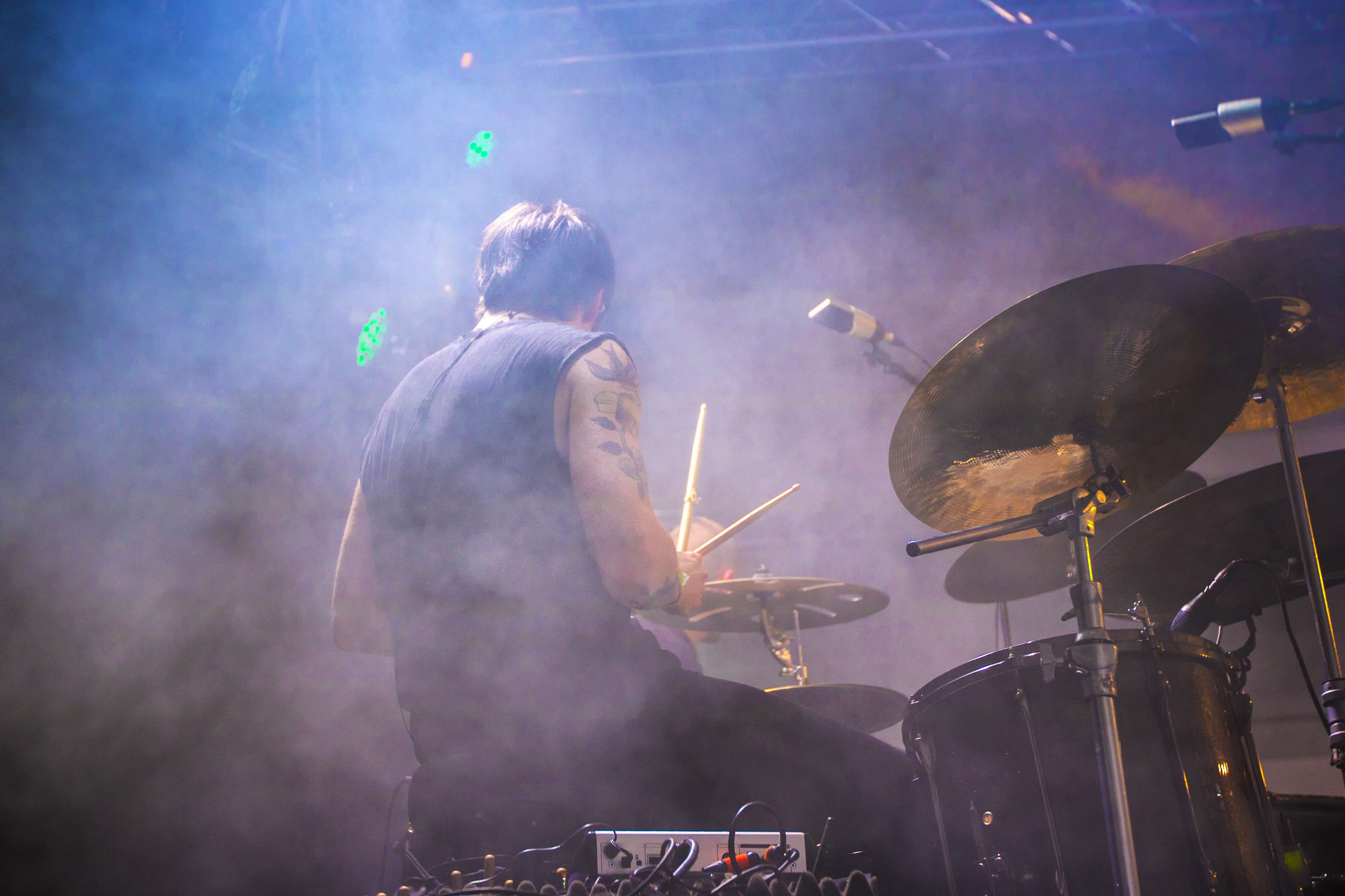 Drummer playing drum set on stage with colored smoke HD Wallpaper
