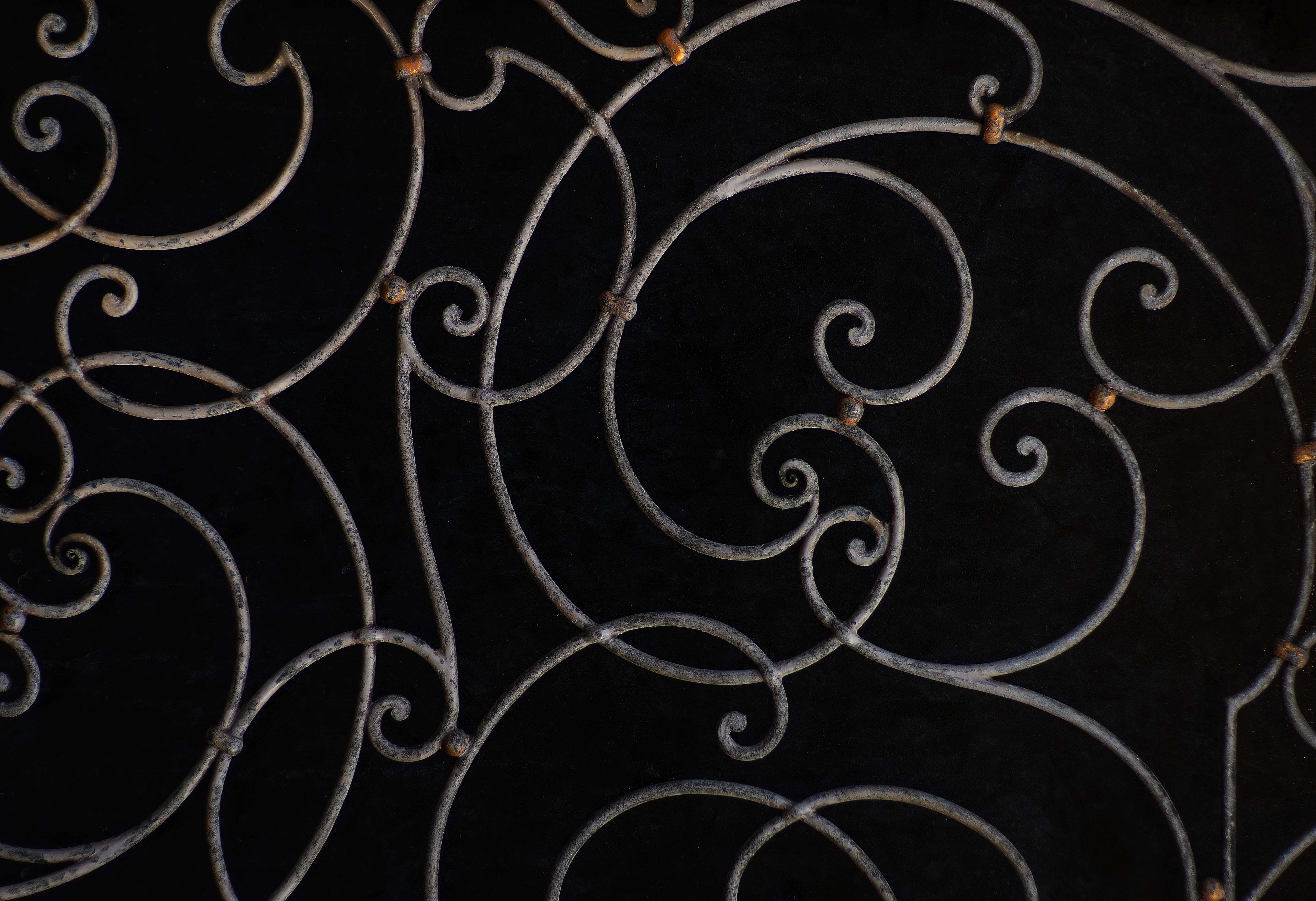 Ornate wrought iron scrollwork pattern on black background HD Wallpaper