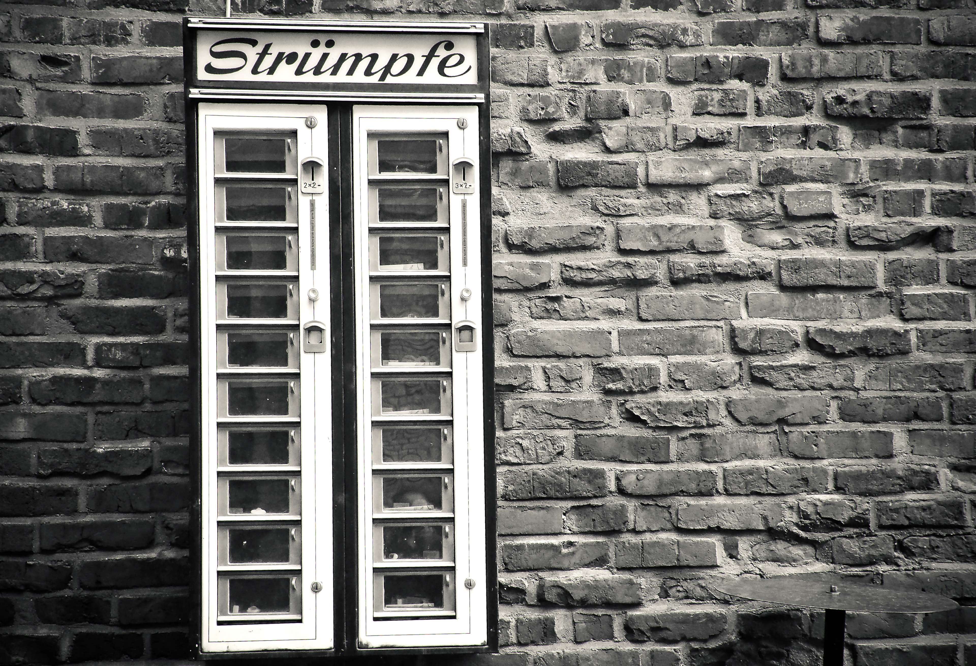 Vintage stocking vending machine on a brick wall HD Wallpaper