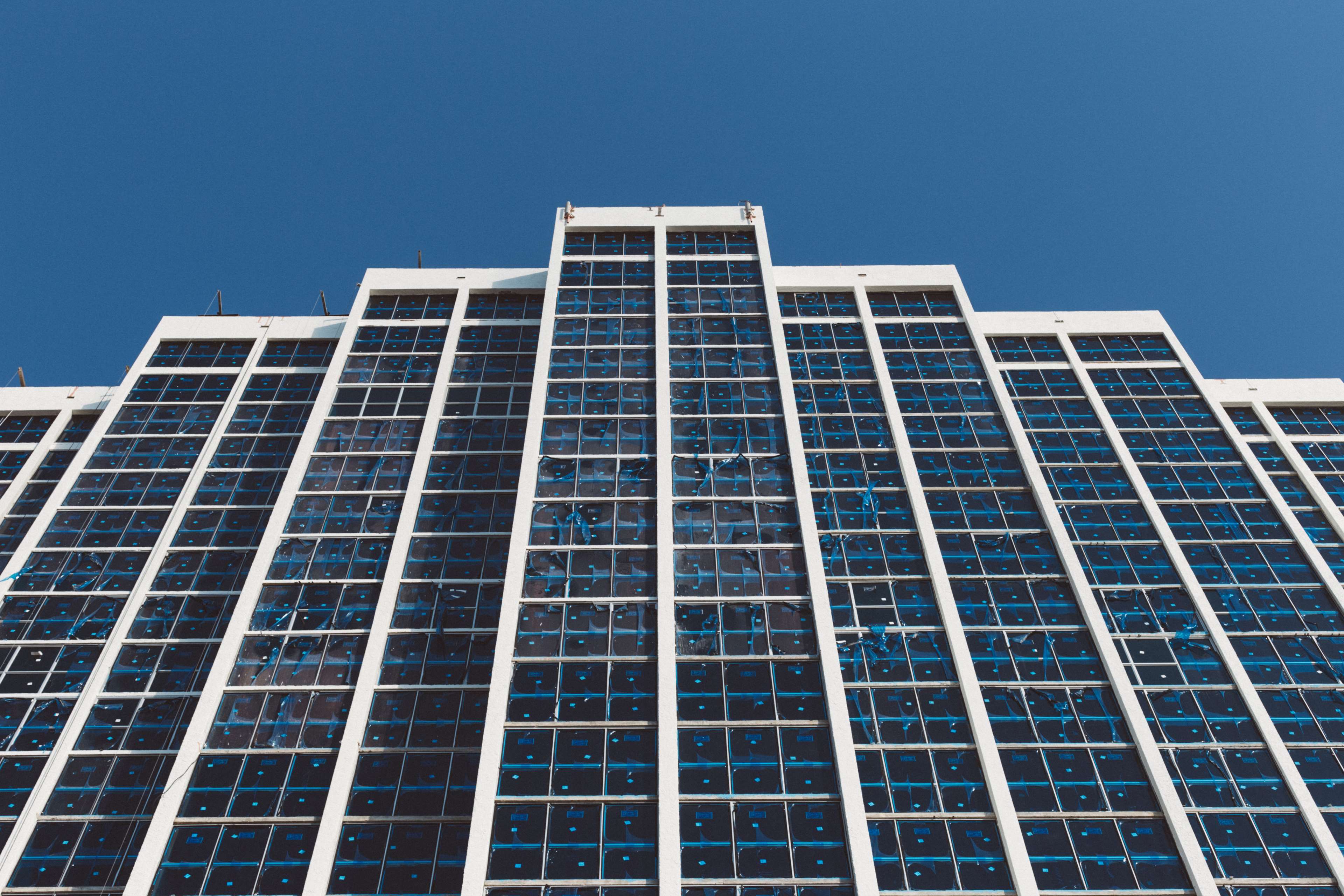 Modern building with glass windows against blue sky HD Wallpaper