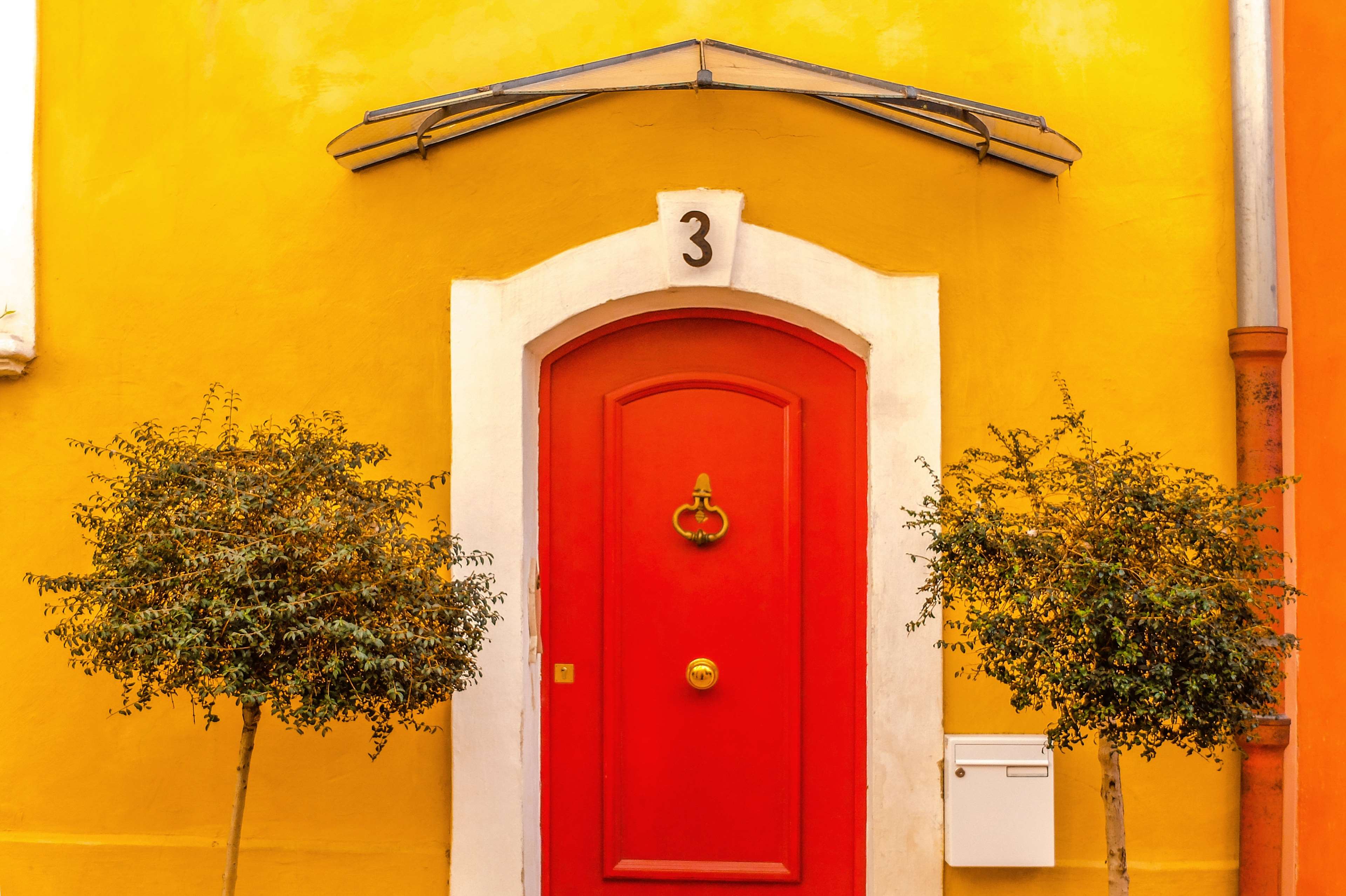 Red door with number 3 on yellow wall in France 4K HD Wallpaper