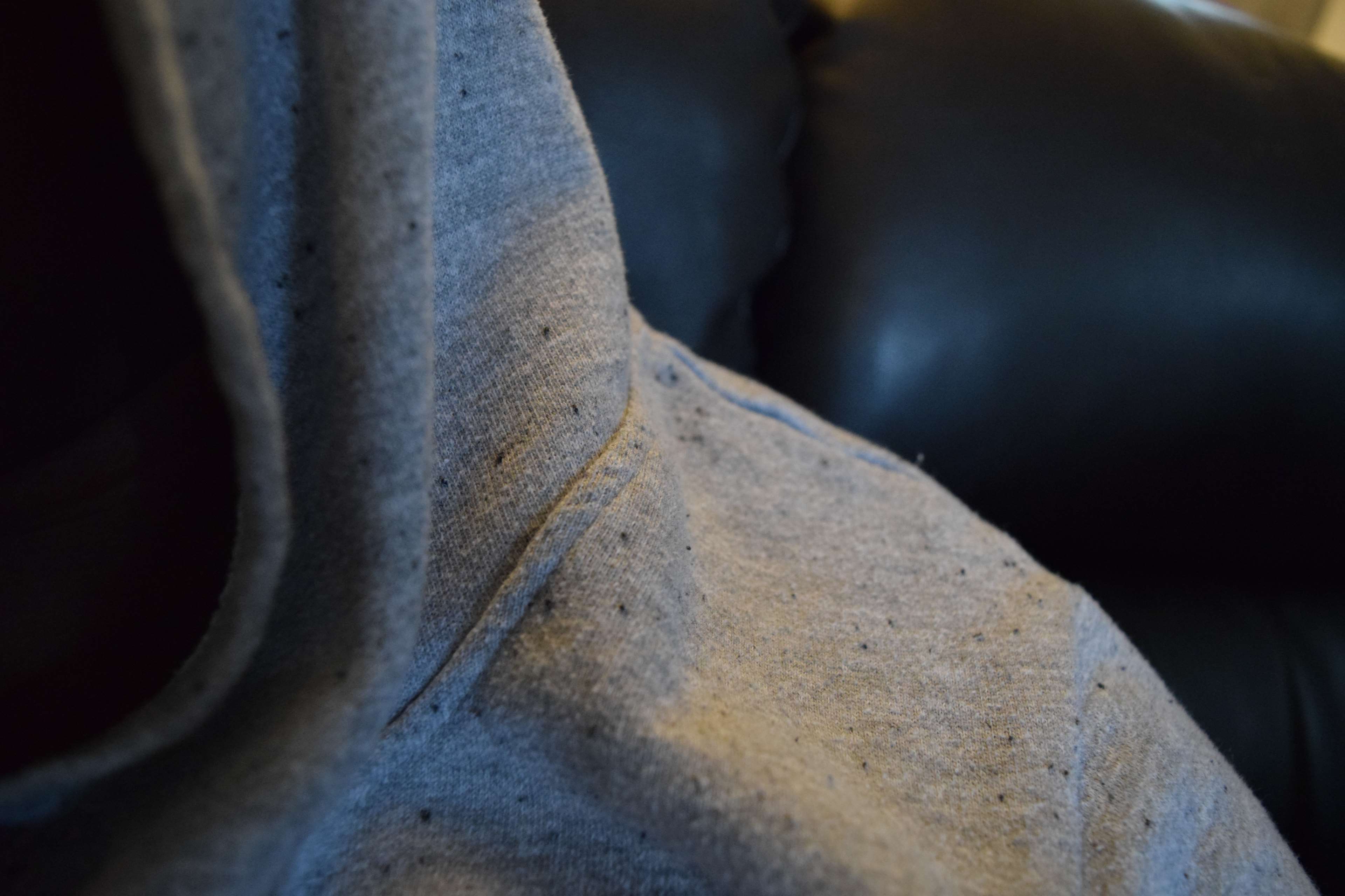 Close up of a grey hoodie with black speckles HD Wallpaper