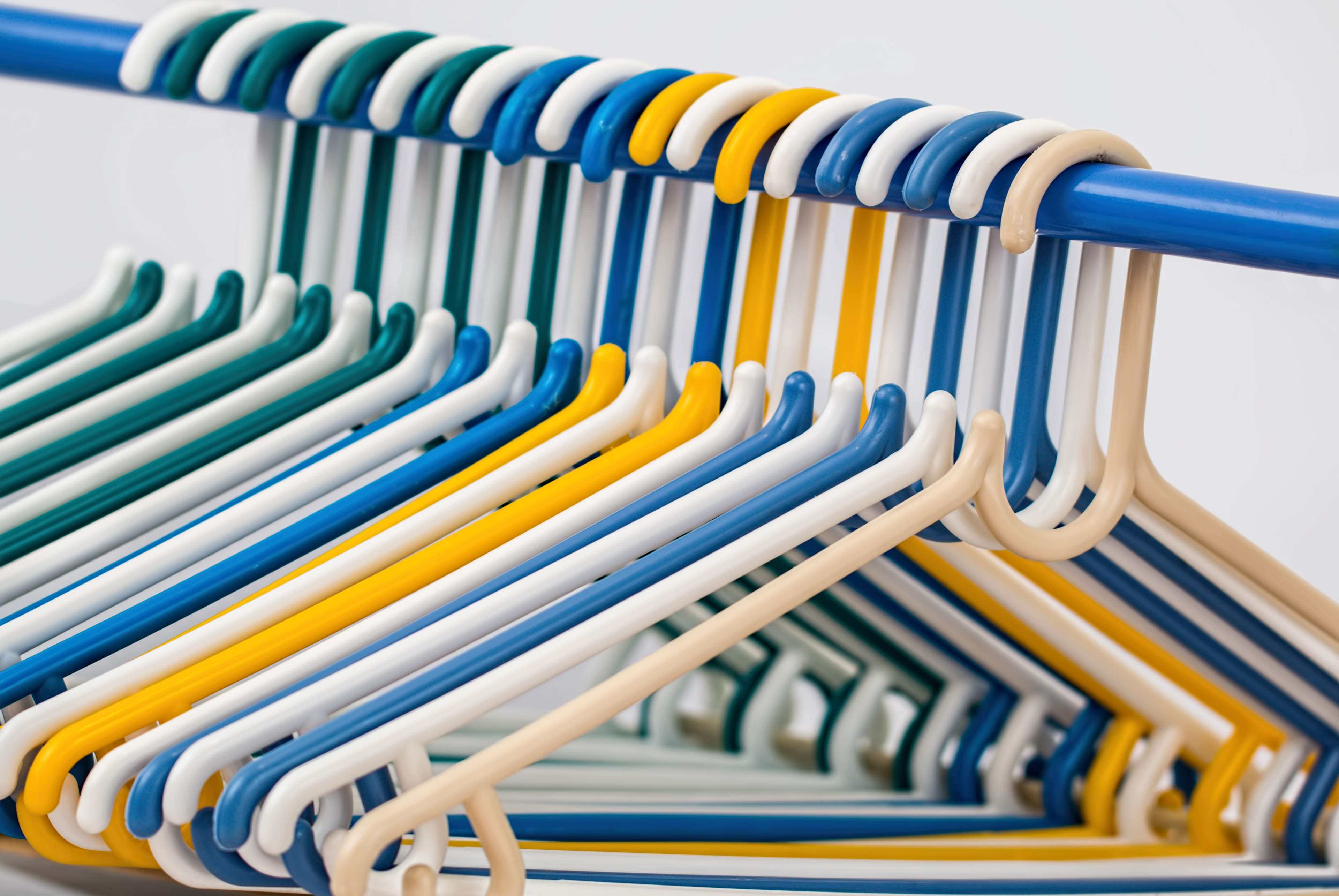 Colorful plastic clothes hangers on a rack 4K HD Wallpaper