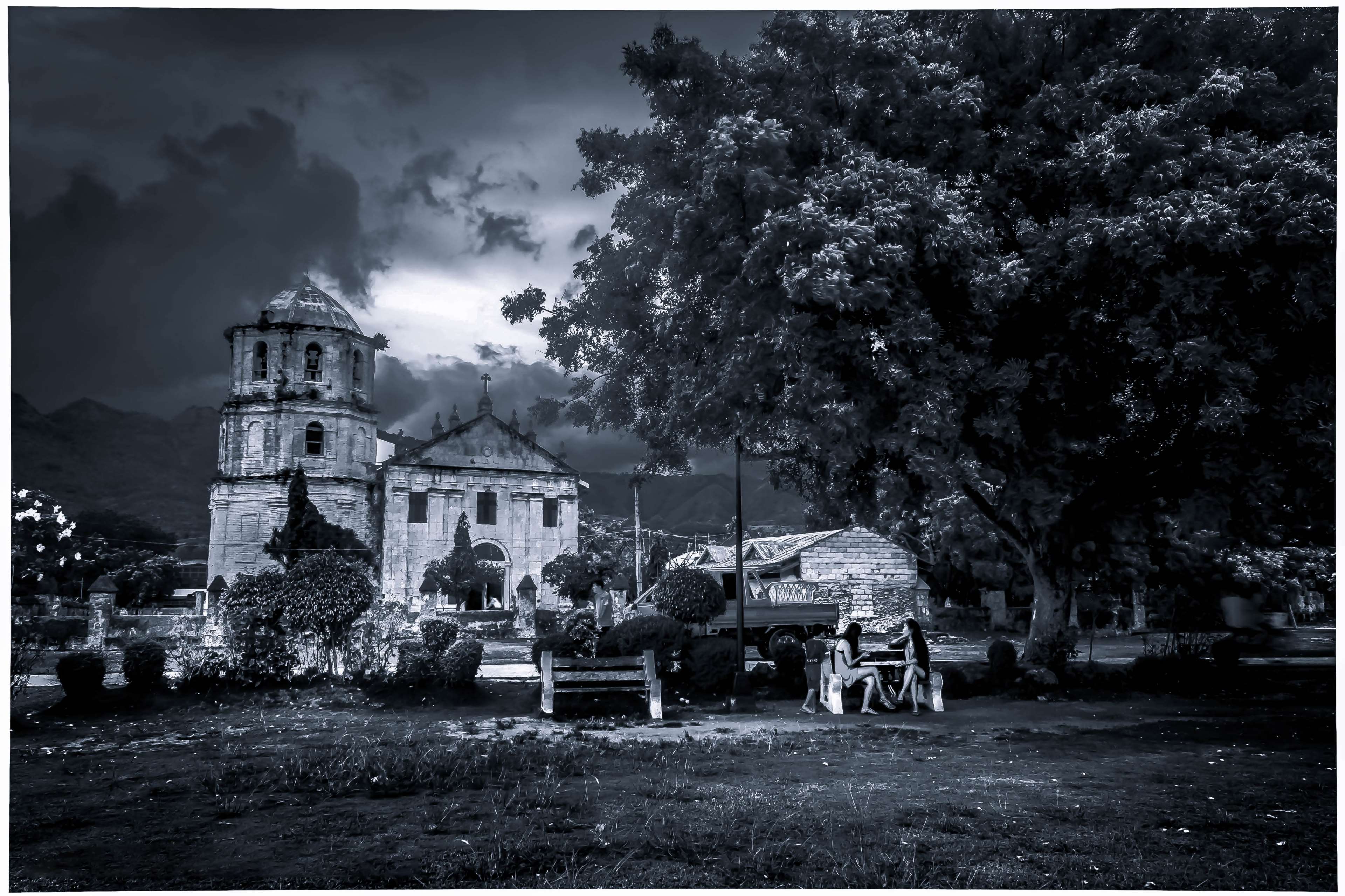Church and tree with people sitting on bench HD Wallpaper