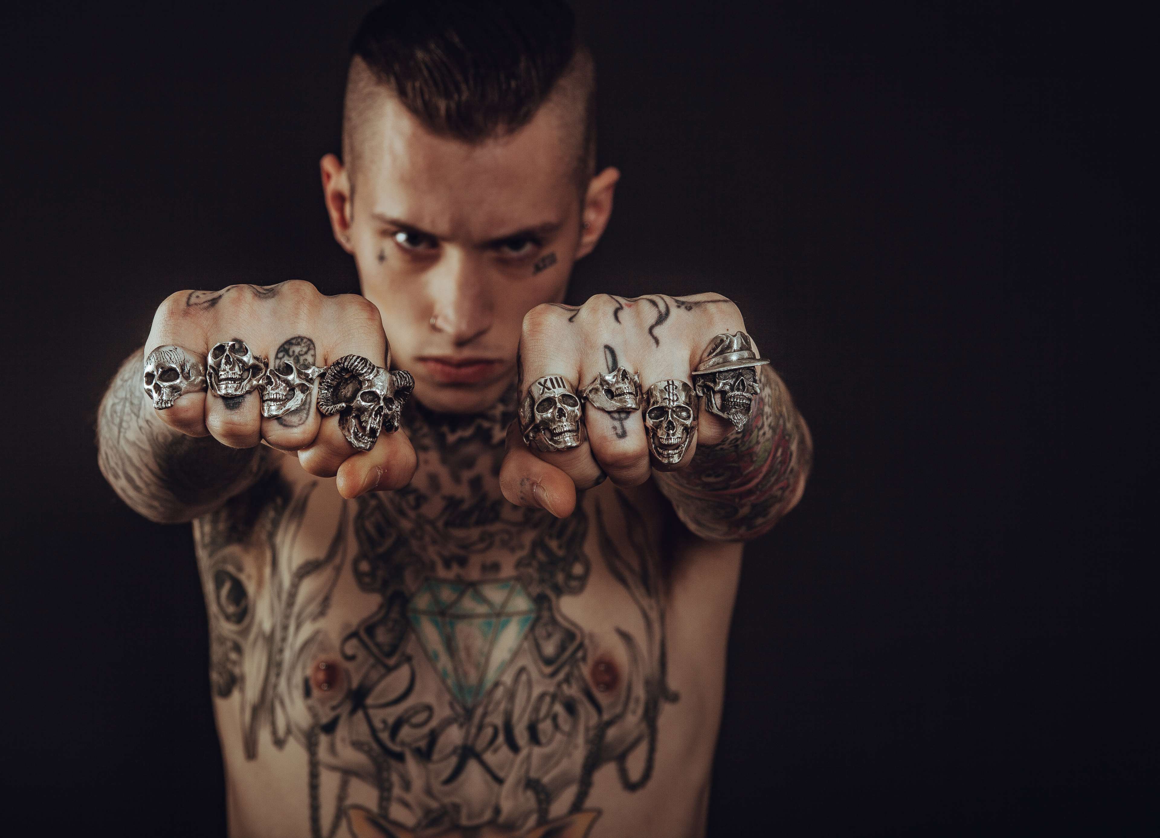 Man with skull rings and tattoos HD Wallpaper