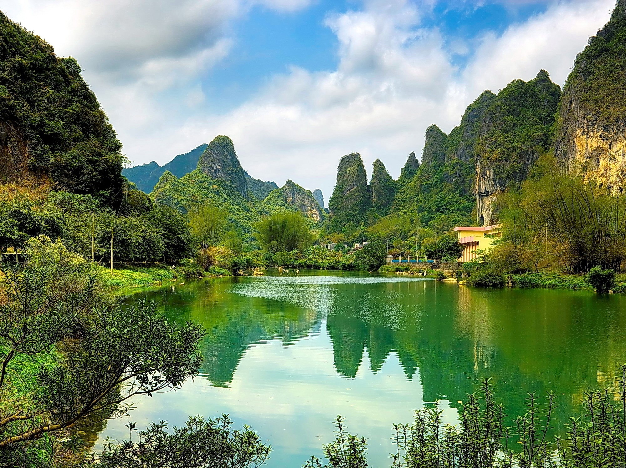 Green lake surrounded by karst mountains in China HD Wallpaper