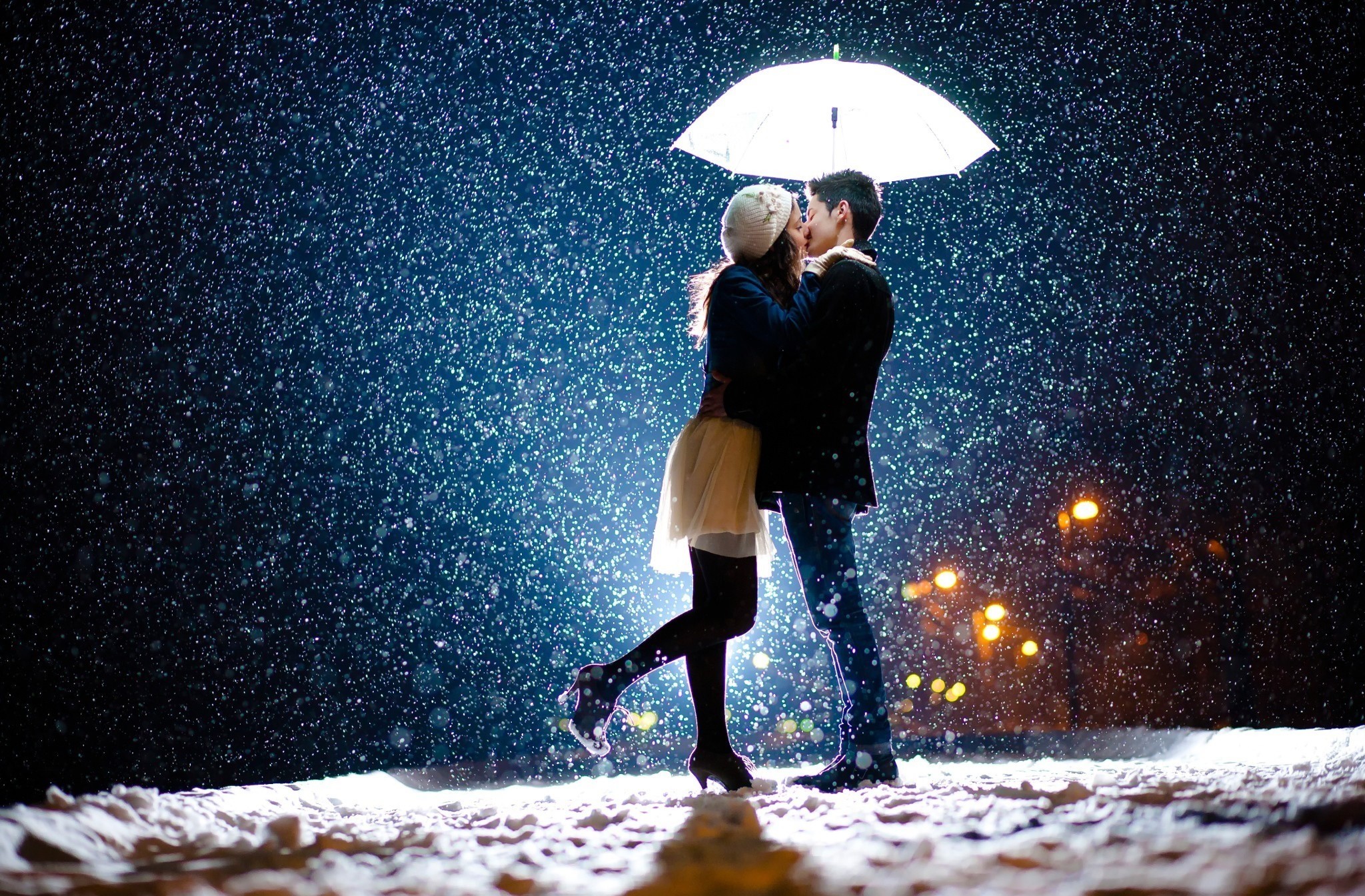 Couple kissing under an umbrella in the snow HD Wallpaper