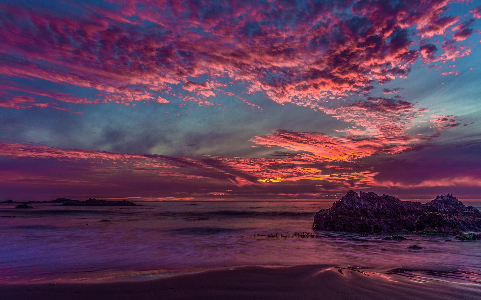 Dramatic sunset over the ocean with colorful clouds and rock formations HD Wallpaper