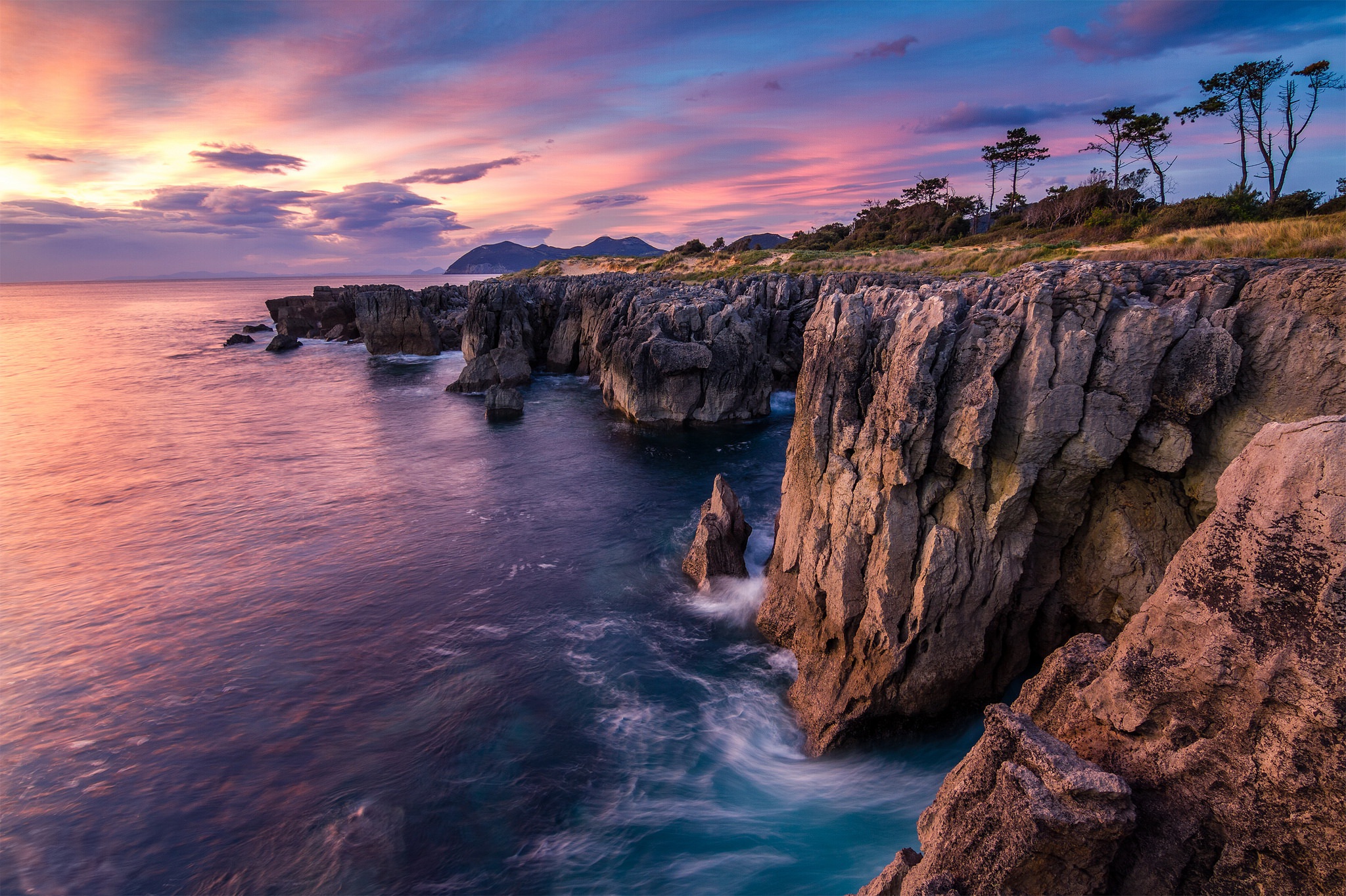 Rocky coastline at sunset with colorful sky HD Wallpaper