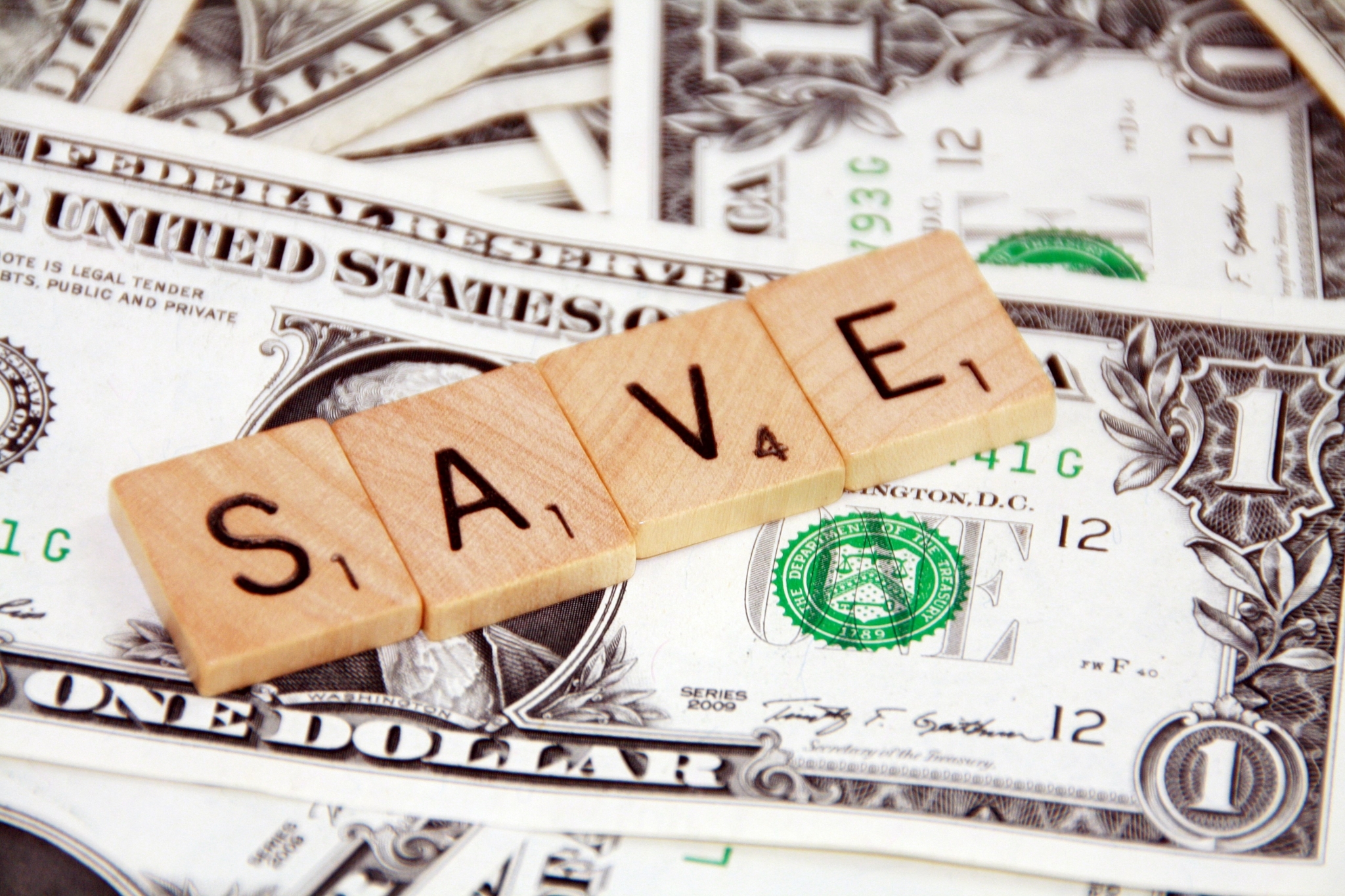 Scrabble tiles spelling SAVE on US dollar bills HD Wallpaper