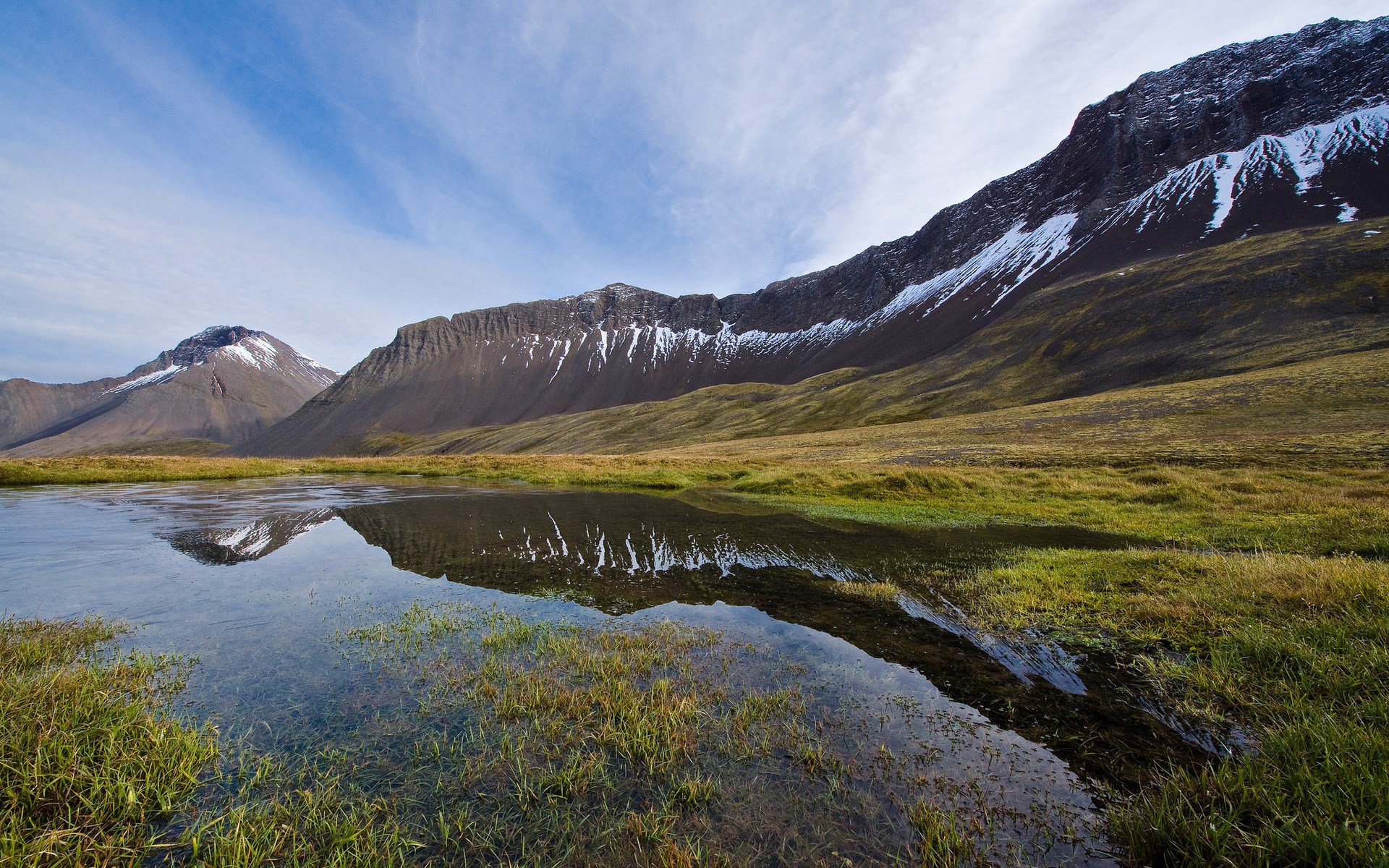 Mountain range reflected in a calm body of water HD Wallpaper