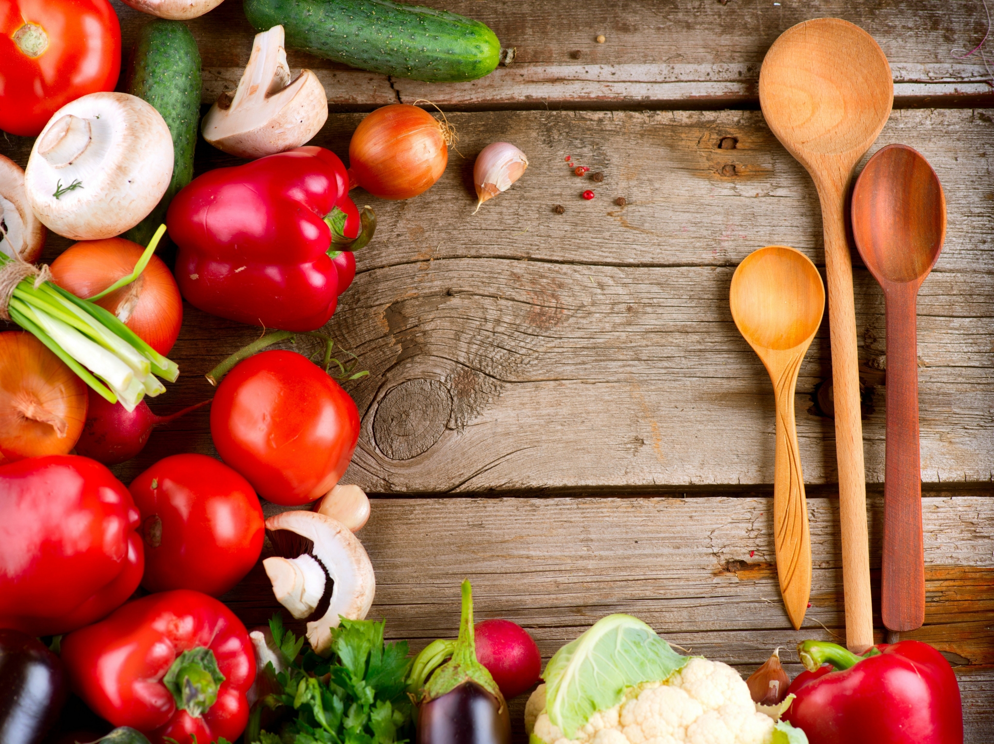 Assortment of fresh vegetables and wooden spoons on a rustic table HD Wallpaper