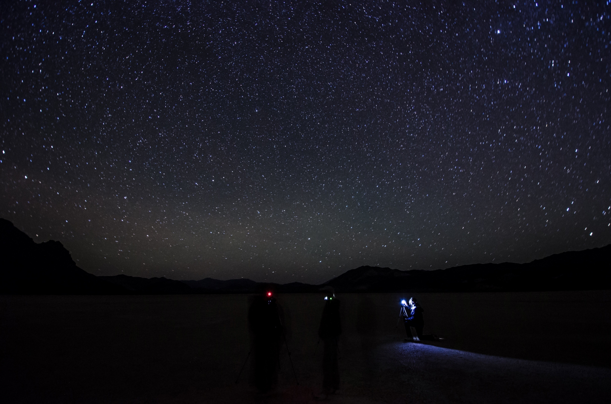 People stargazing on a dark plain HD Wallpaper