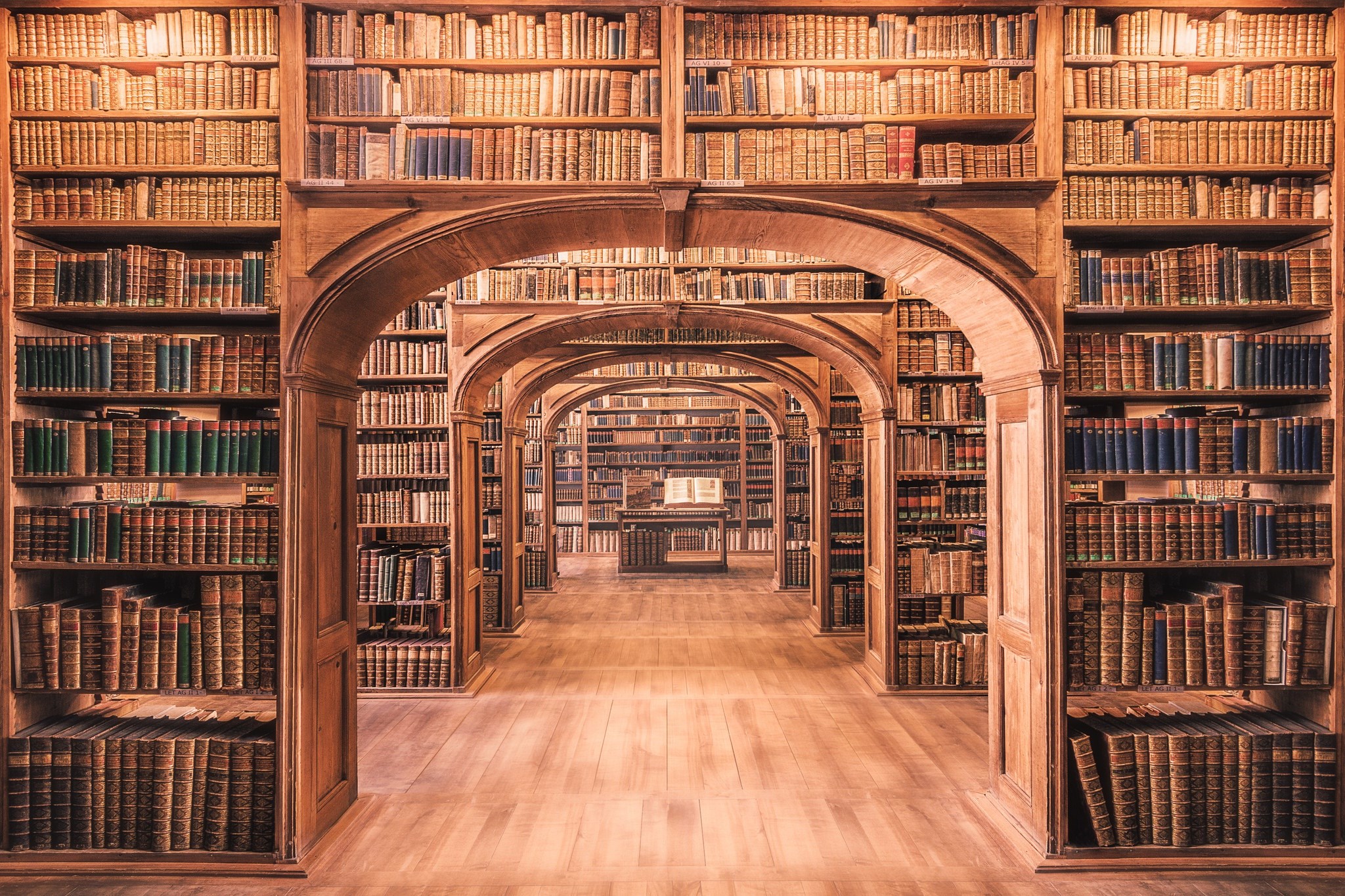 Library interior with arched doorways and bookshelves HD Wallpaper