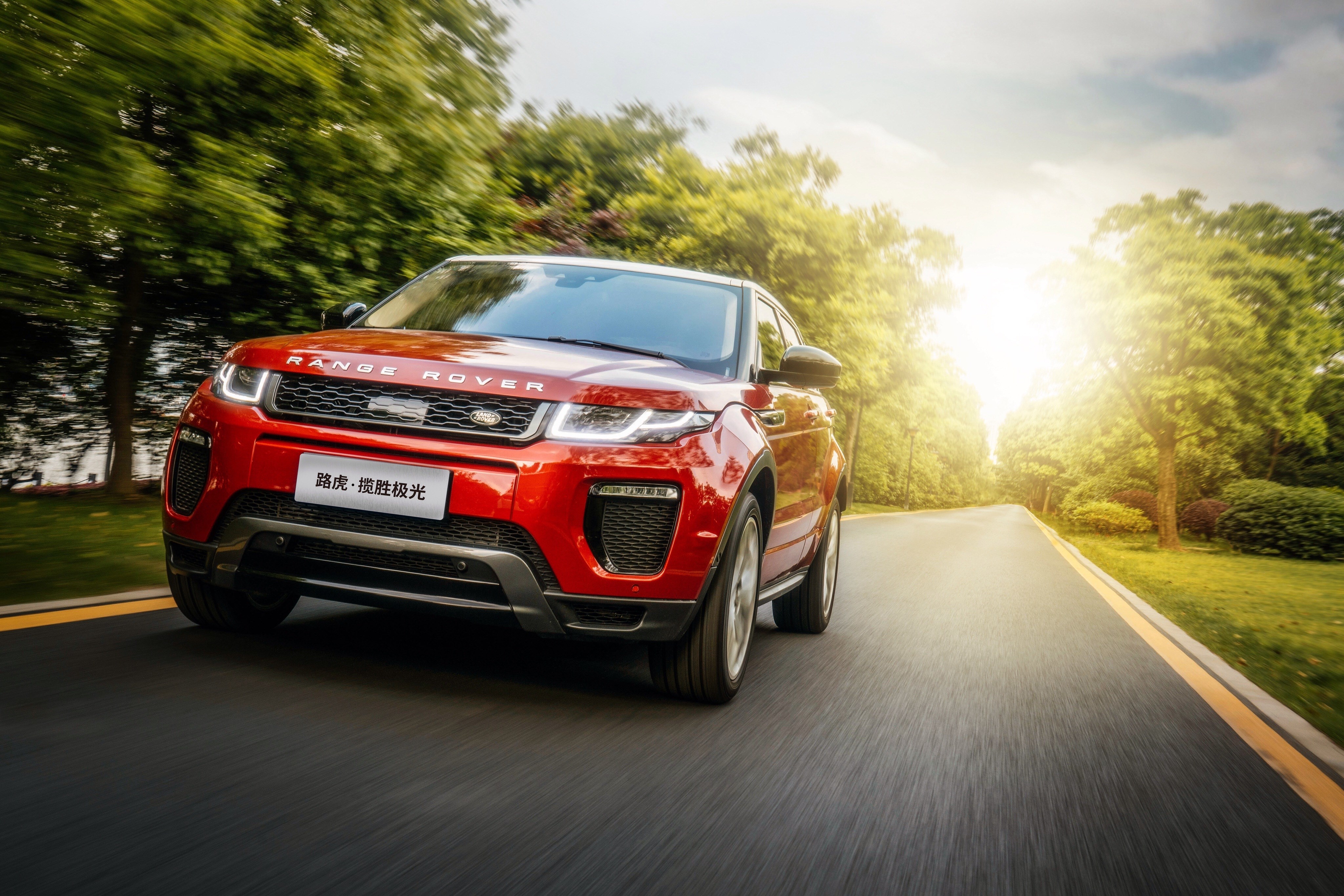 Red Range Rover Evoque driving on a road HD Wallpaper