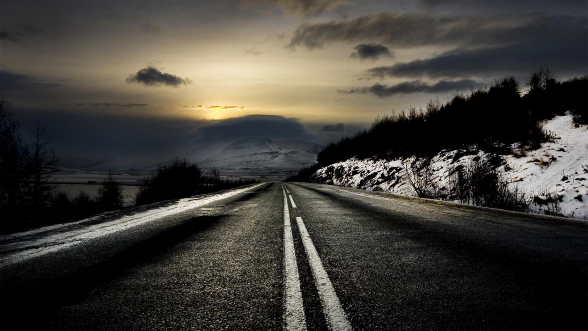 Road through a snowy landscape at sunset HD Wallpaper
