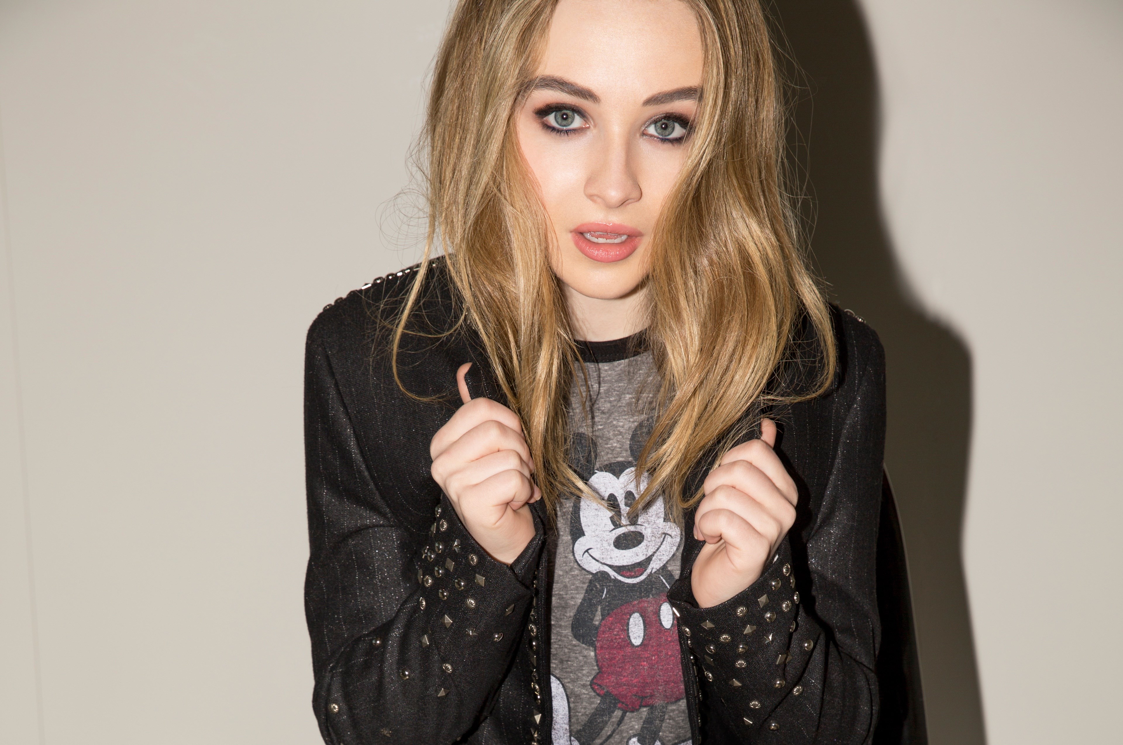 Sabrina Carpenter wearing a Mickey Mouse t-shirt and studded jacket HD Wallpaper