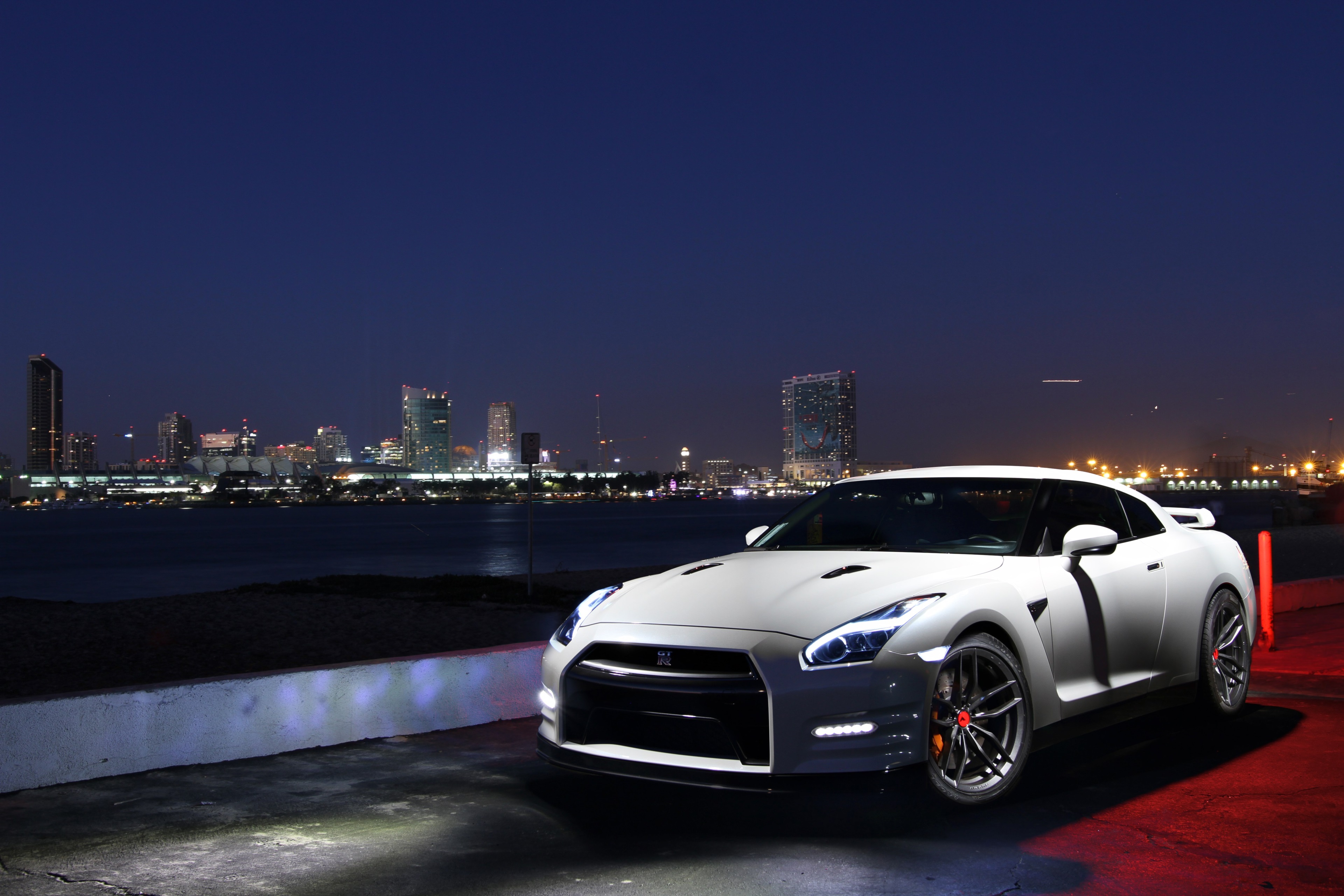 White Nissan GT-R parked by the water at night HD Wallpaper