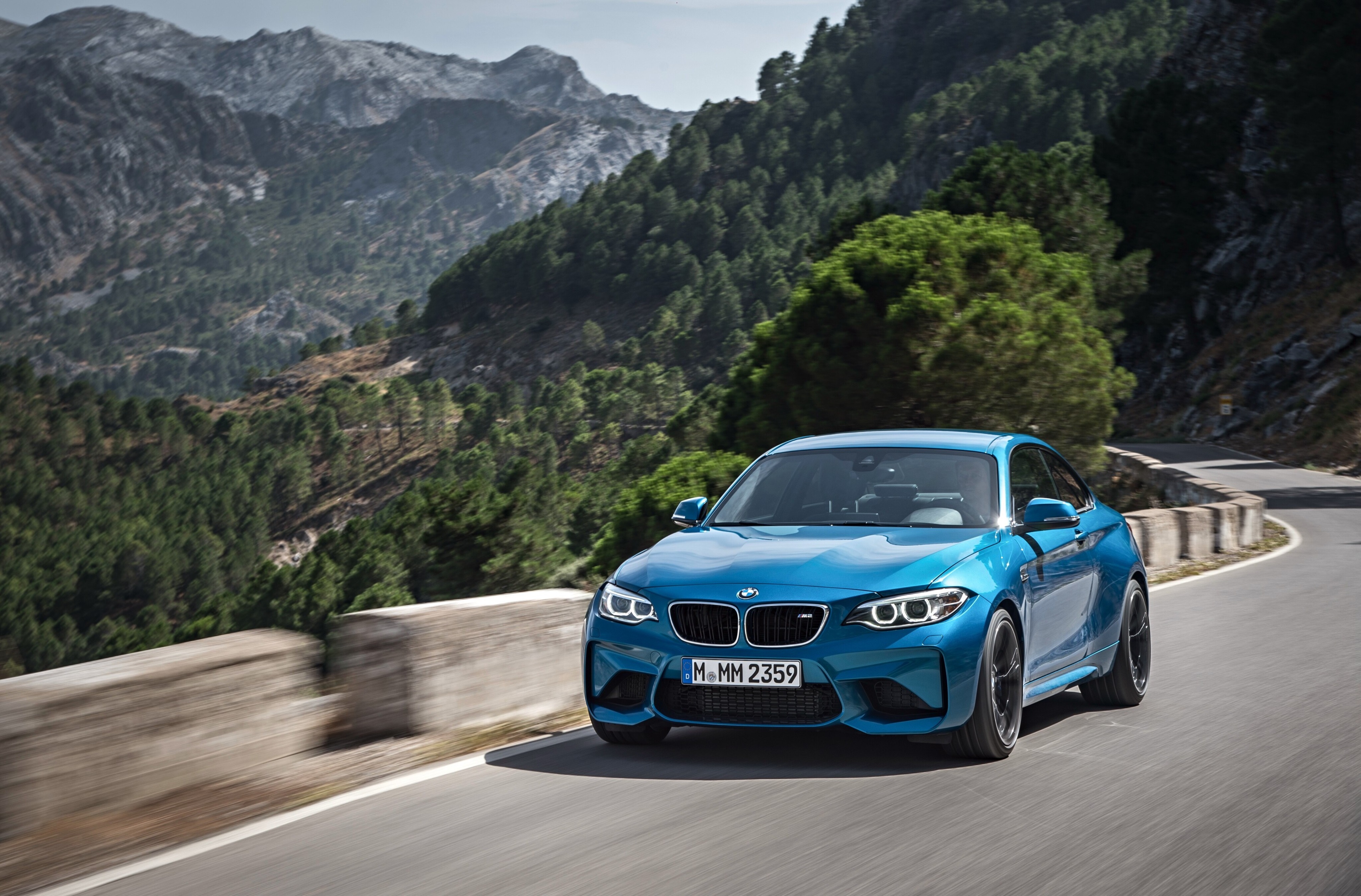 Blue BMW M2 driving on a mountain road HD Wallpaper